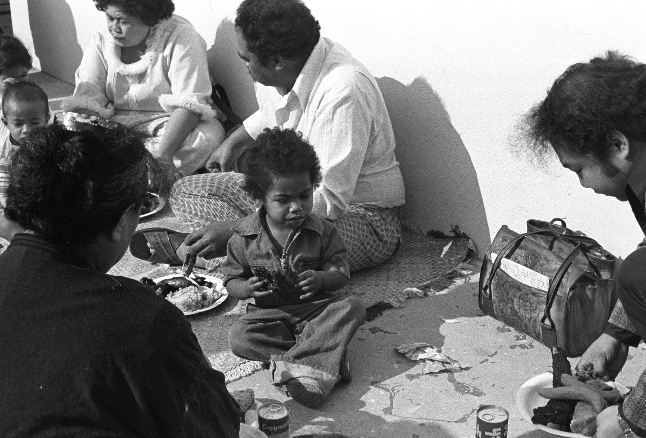 Church Service and Cookout (1972),
Church members and kids sitting on the floor eating.
Photographed by Visual Communications