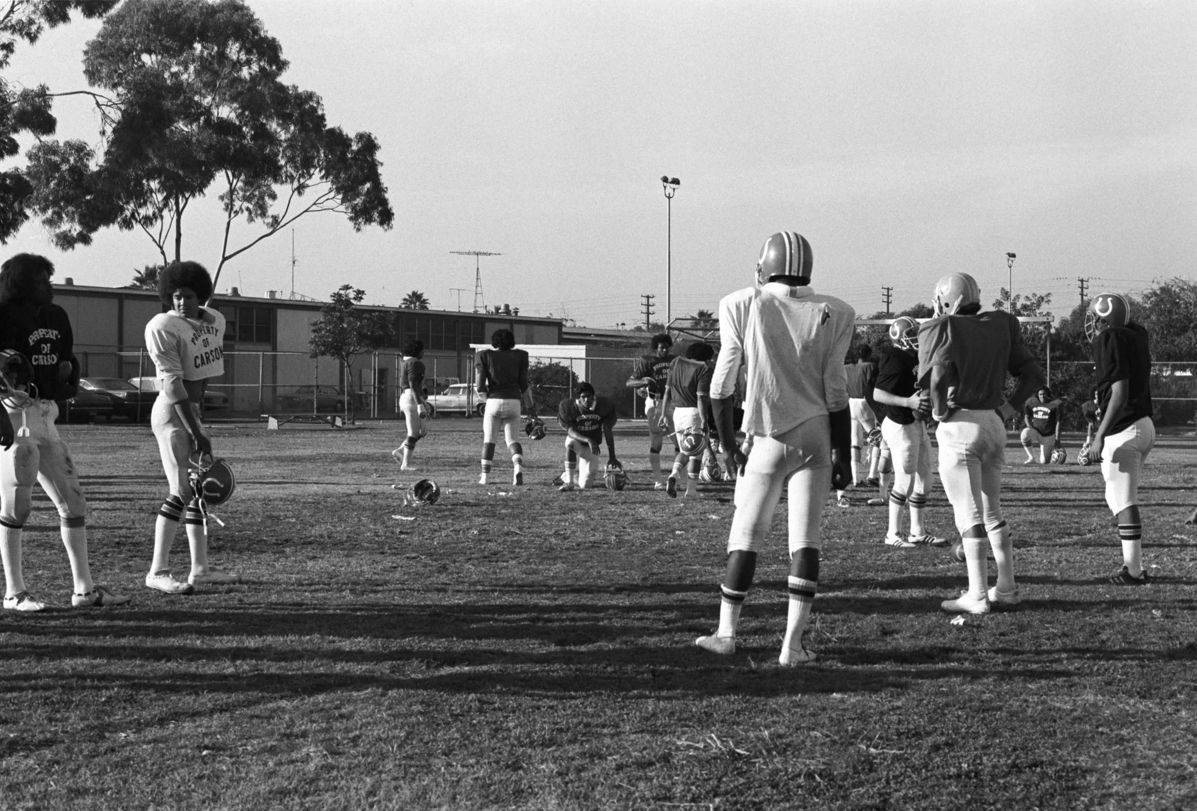 Omai Fa'atasi - Football Team in Carson California (1977-1978),
Football players on the field between plays at Carson High School.
Photographed by Visual Communications