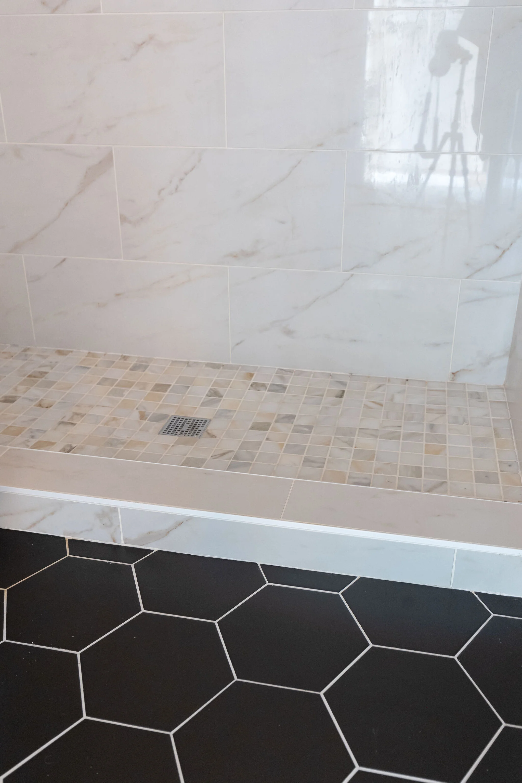 bathroom with marble and black hex tile