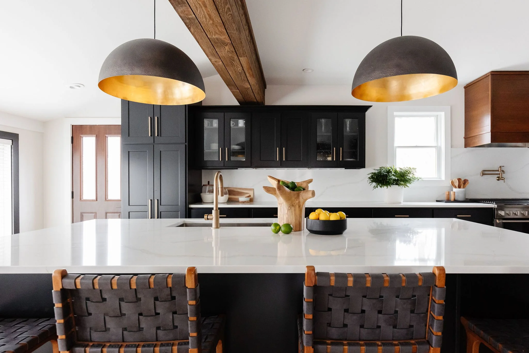 black and gold pendant lights over island