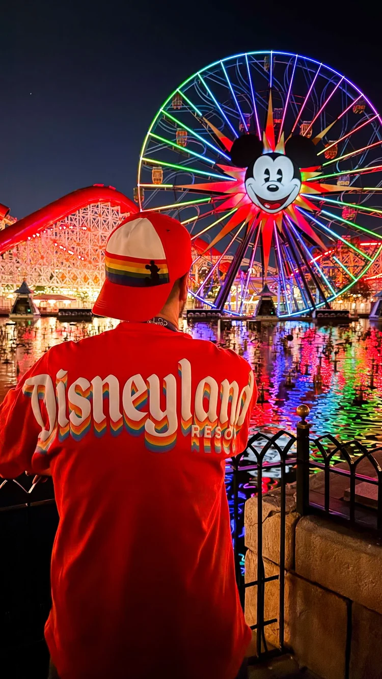 A traveler in a rainbow Disneyland Resort jacket