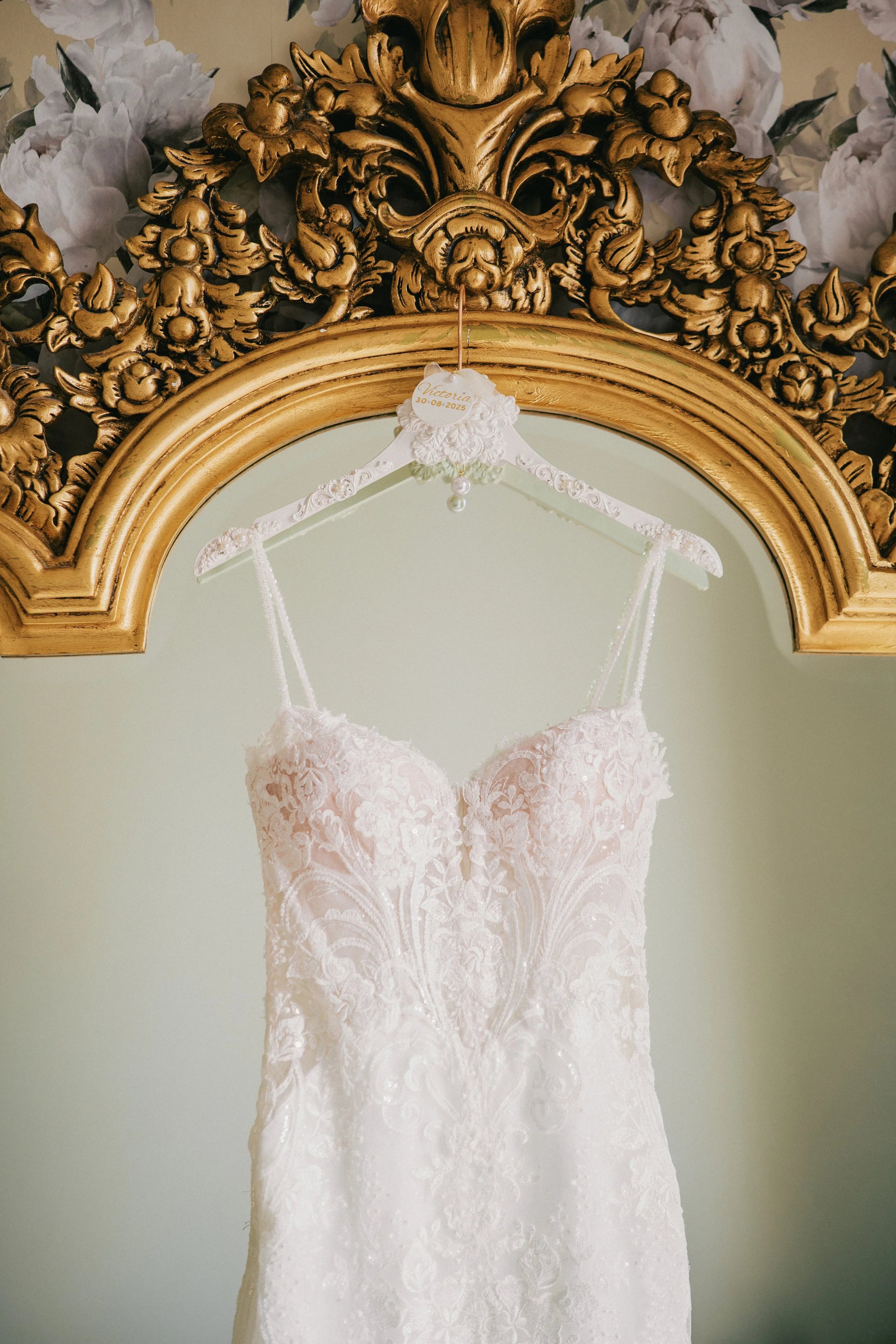 Wedding dress hung on gold mirror