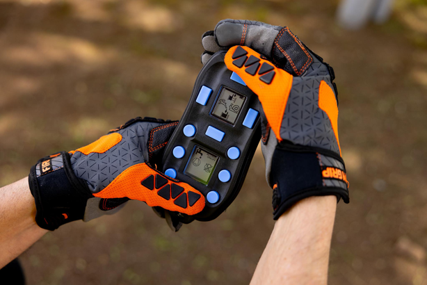 Person wearing protective gloves holding Handheld Remote Control