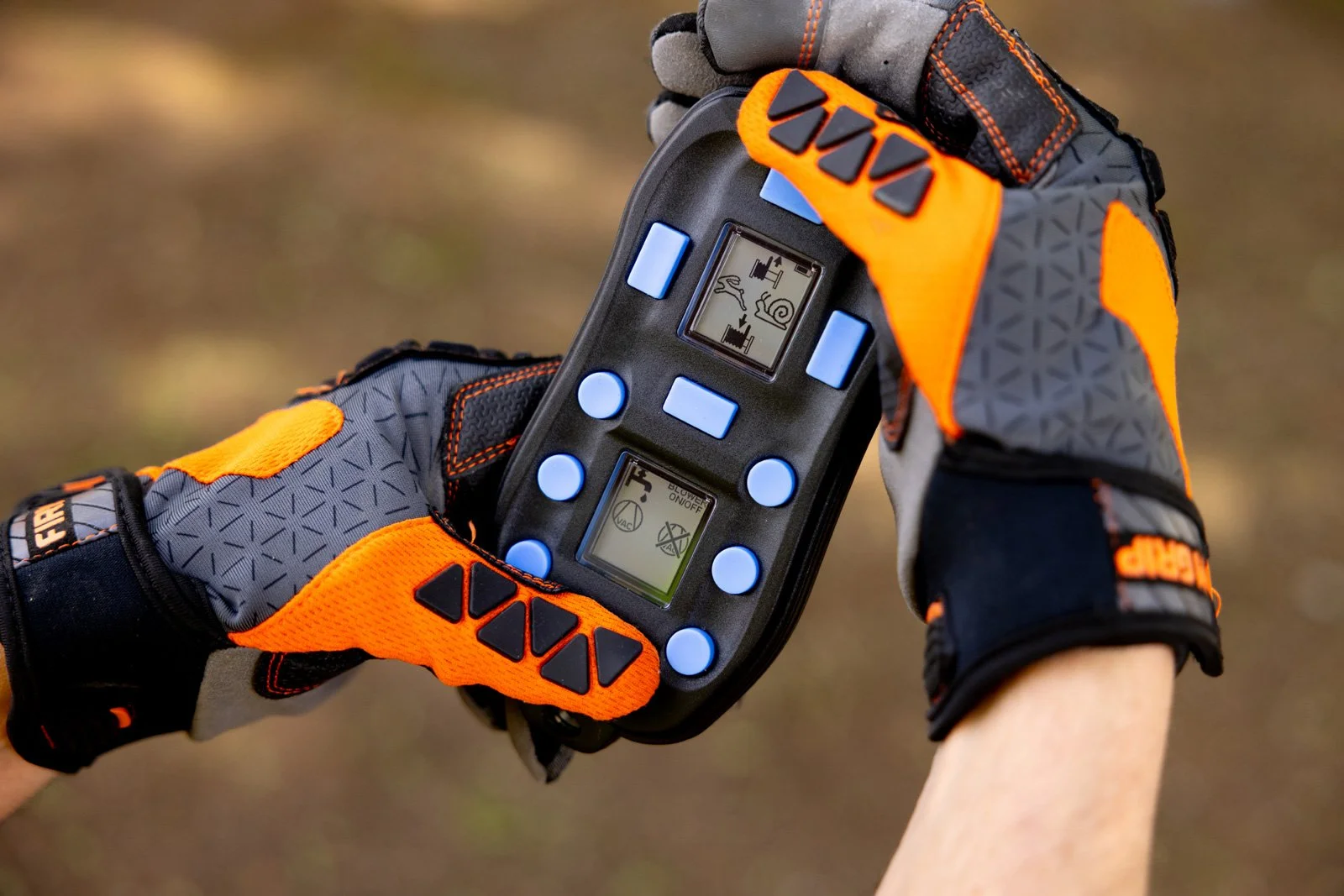 Person wearing protective gloves holding remote device