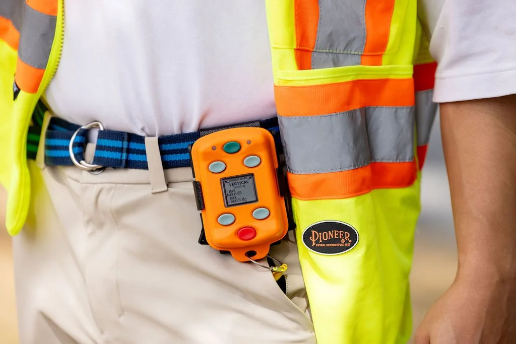Man wearing construction vest and kill switch device on belt