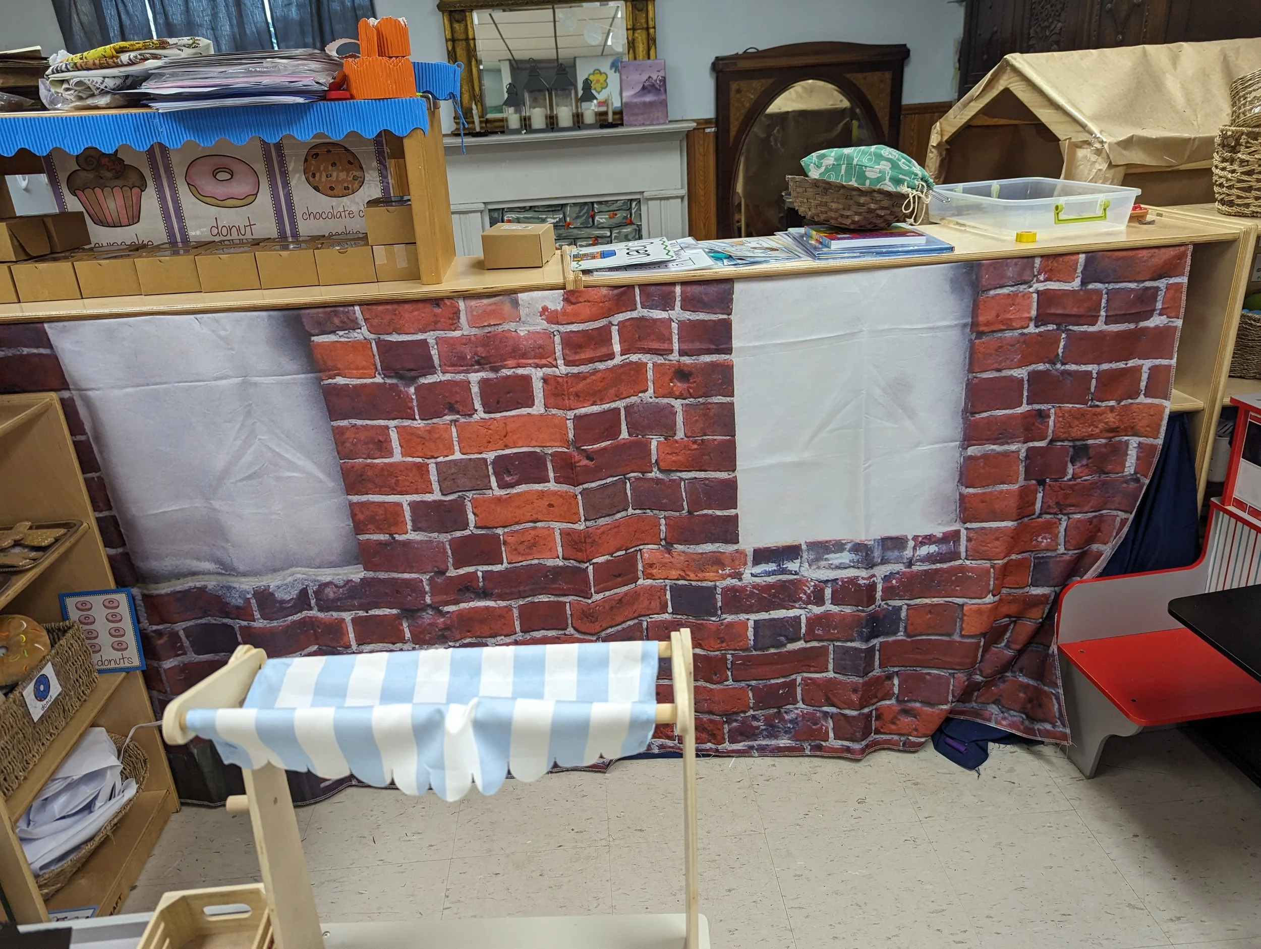 A small market themed play area selling cupcakes, donuts, and cookies.