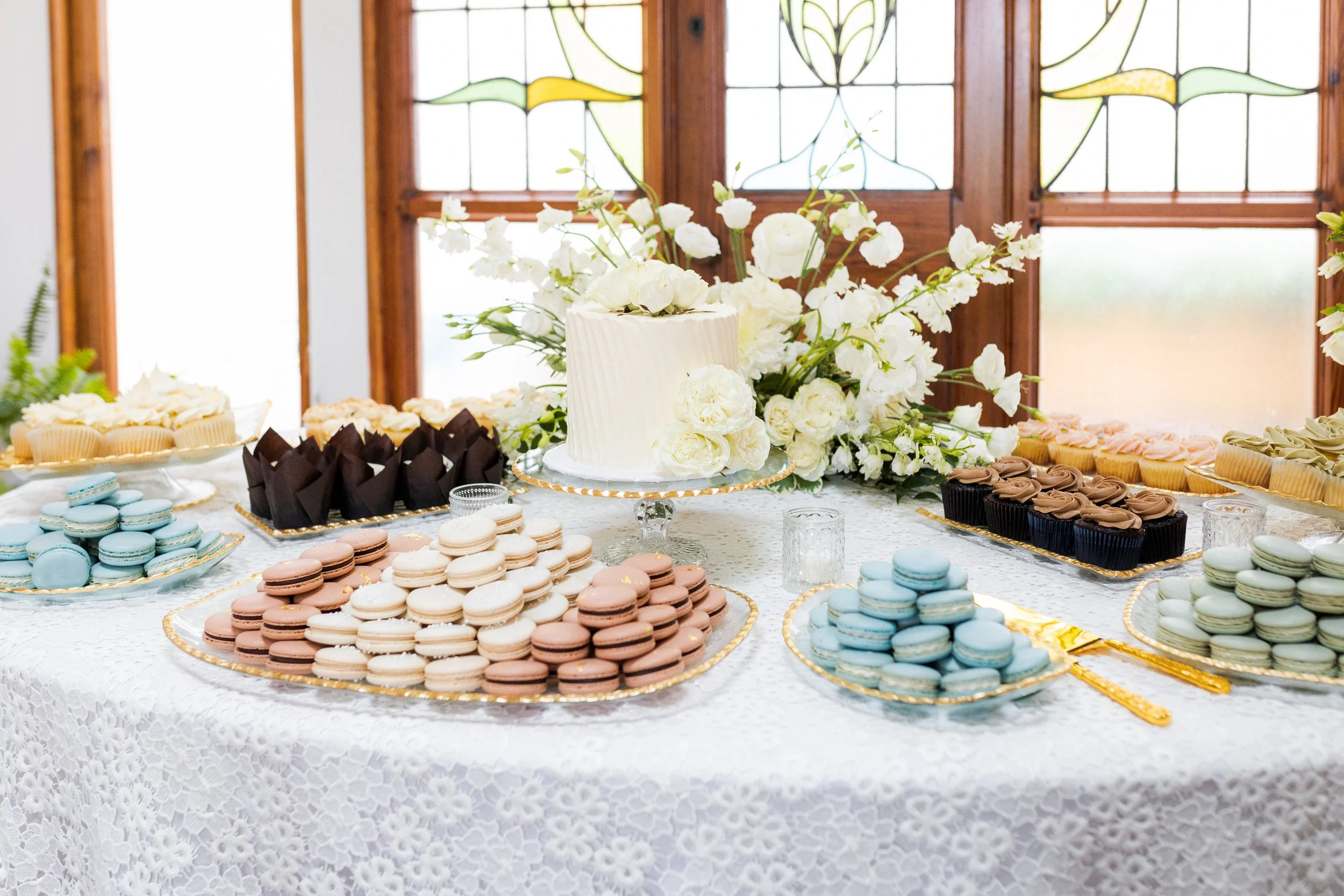 Three tier wedding cake with cascade of macarons and roses.