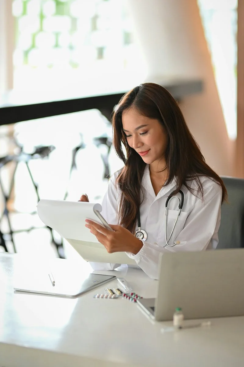 A smiling young physician looks at results of a comprehensive women's hormone panel