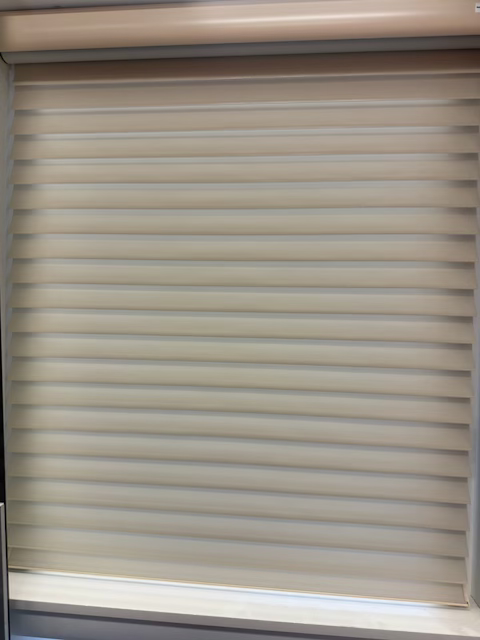Room darkening honeycomb cellular shades in beige showing light filtering through fabric in window