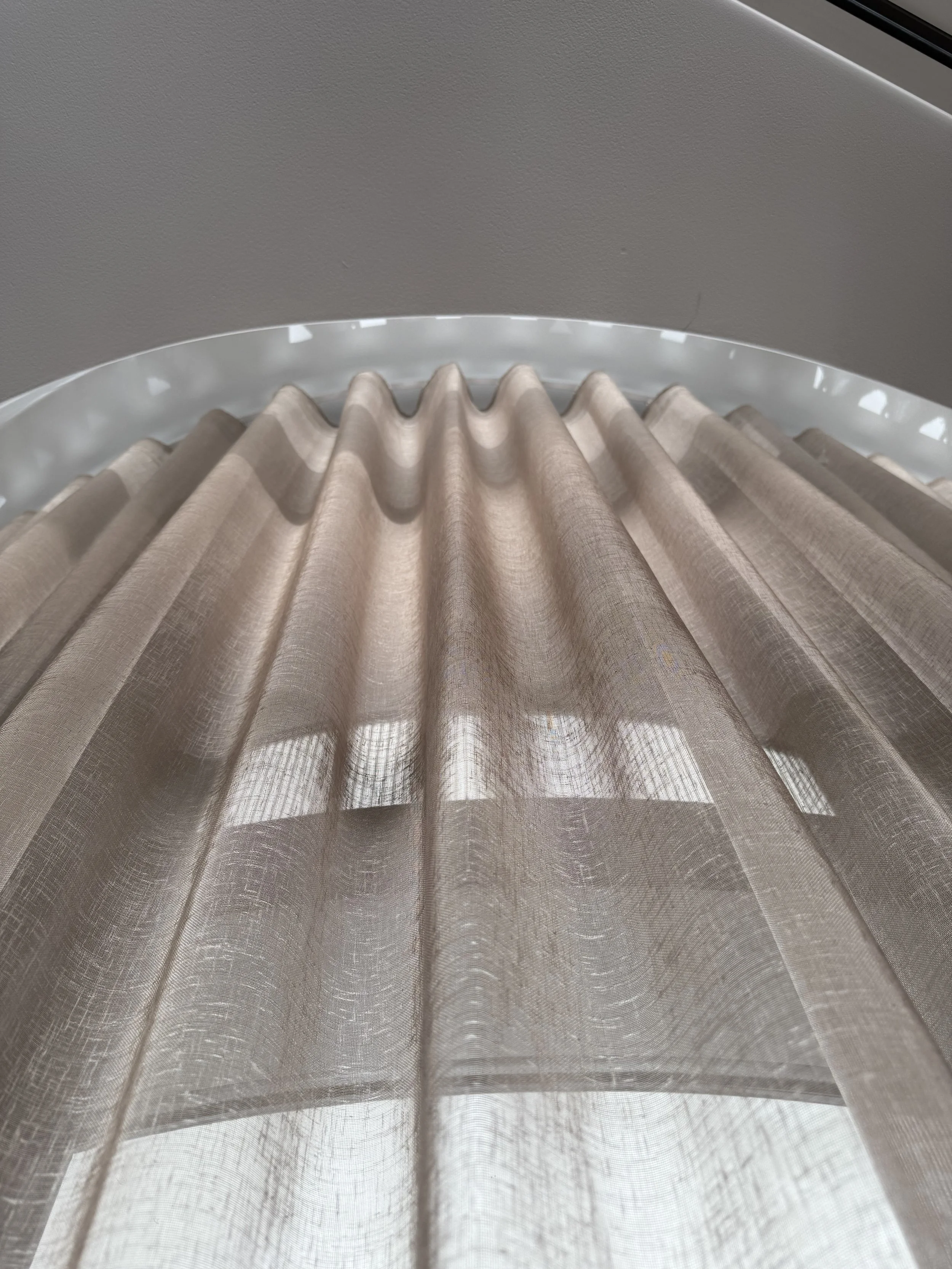 S-Wave curtain heading detail showing uniform wave folds in warm sand linen sheer, integrated into a curved ceiling track - premium 2026 specification