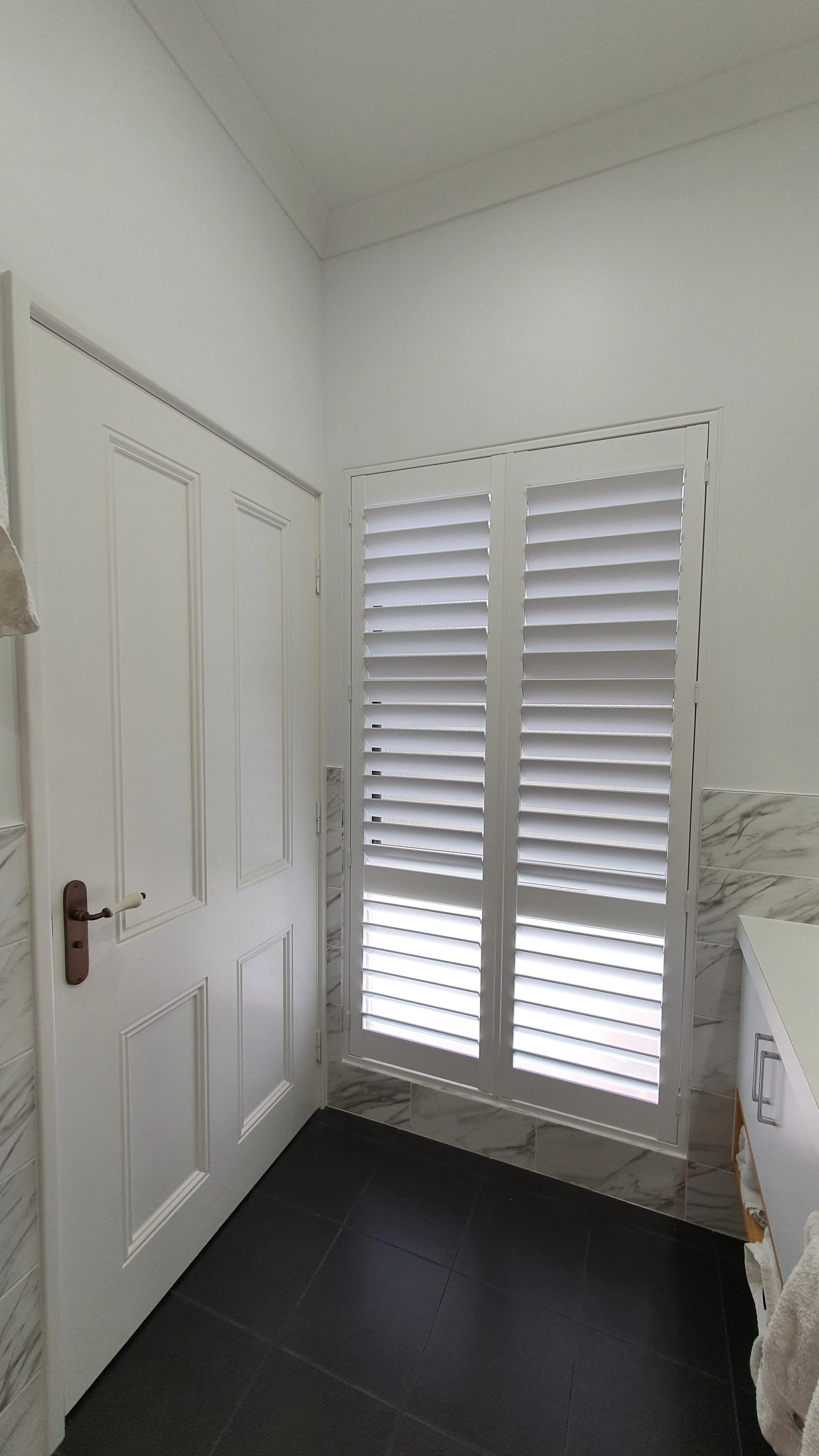 White PolySatin shutters covering a window in a Perth laundry room