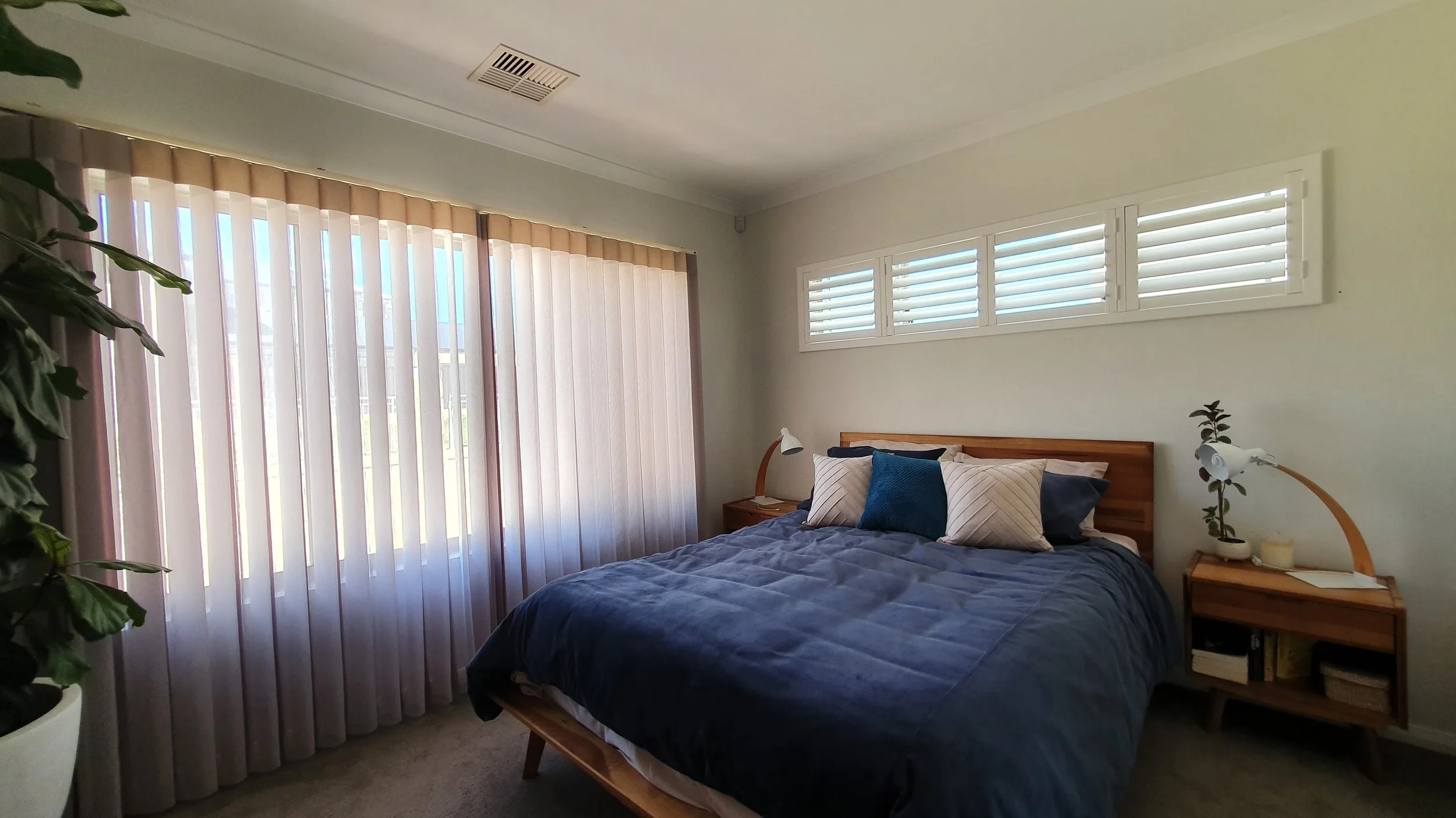PolySatin plantation shutters on a highlight window looking cohesive with curtains