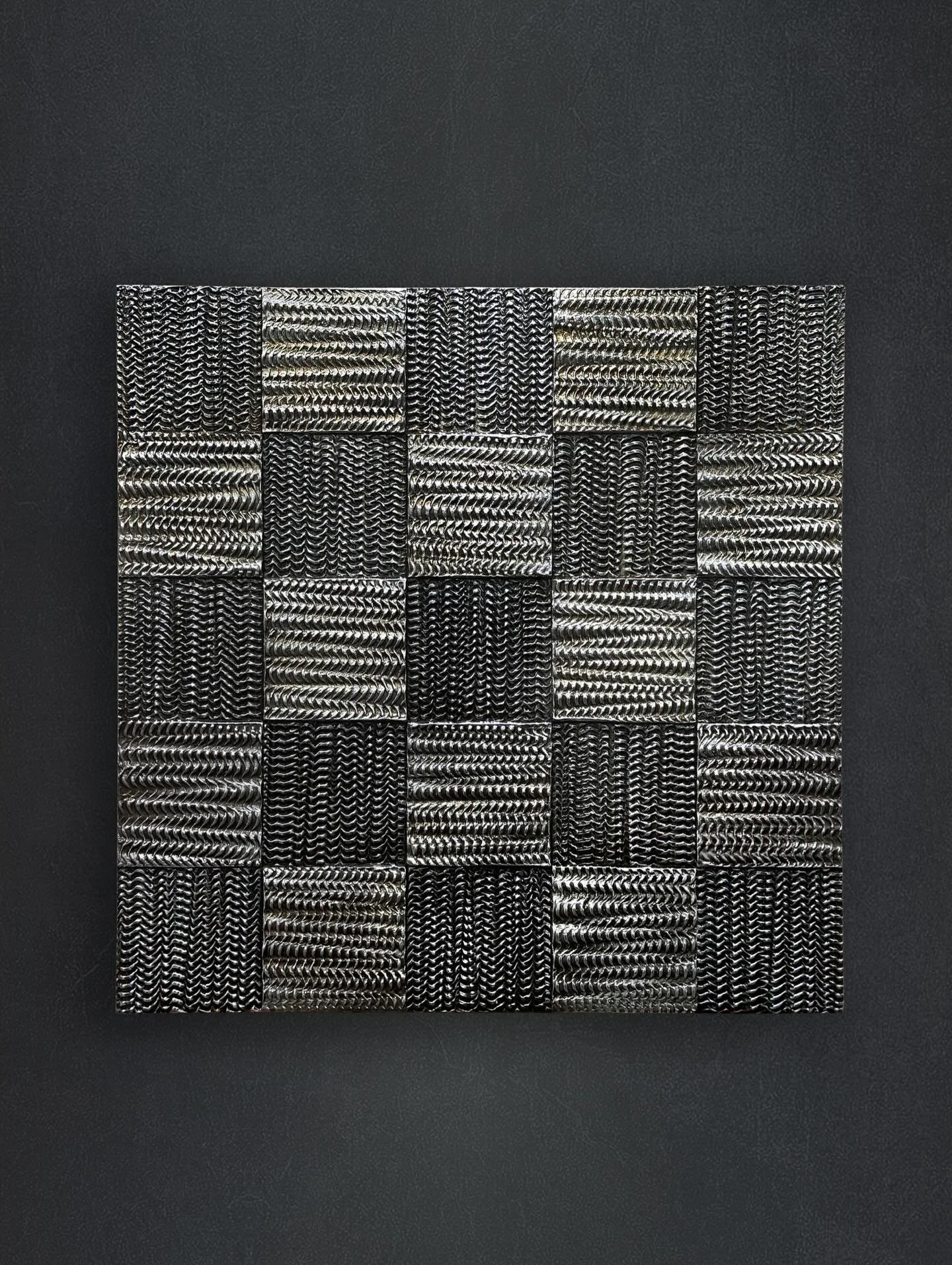 𝘋𝘢𝘮𝘪𝘦𝘳 𝘛𝘸𝘦𝘦𝘥 𝘚𝘪𝘭𝘷𝘦𝘳, explores vibration into matter, a field of repeating frequencies pressed into relief. Each square carries its own pulse, a quiet reverberation that shifts as light moves across, like visual echo suspended in time