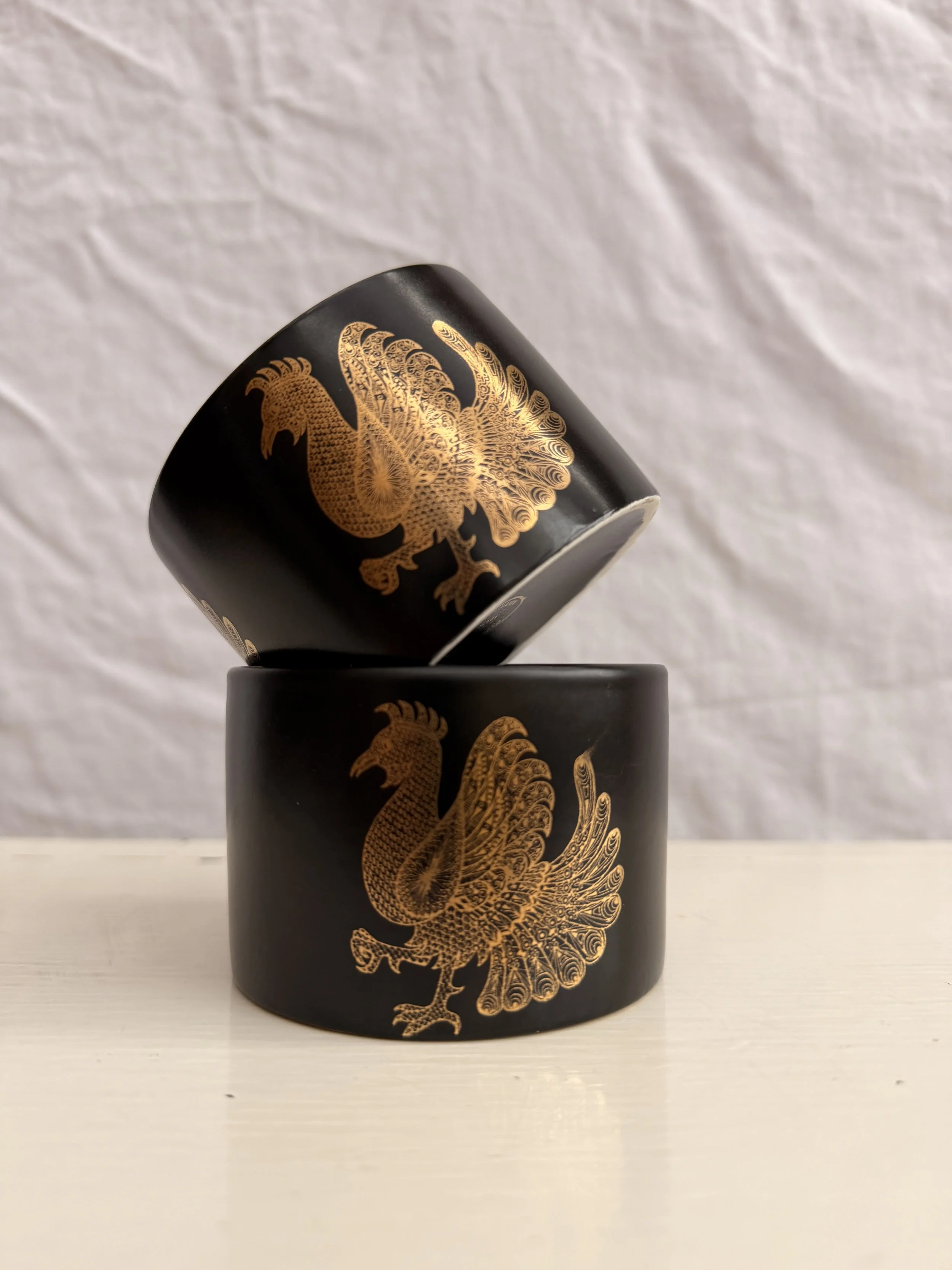 A vintage Portmeirion Phoenix sugar bowl featuring a gold phoenix design on black ceramic.