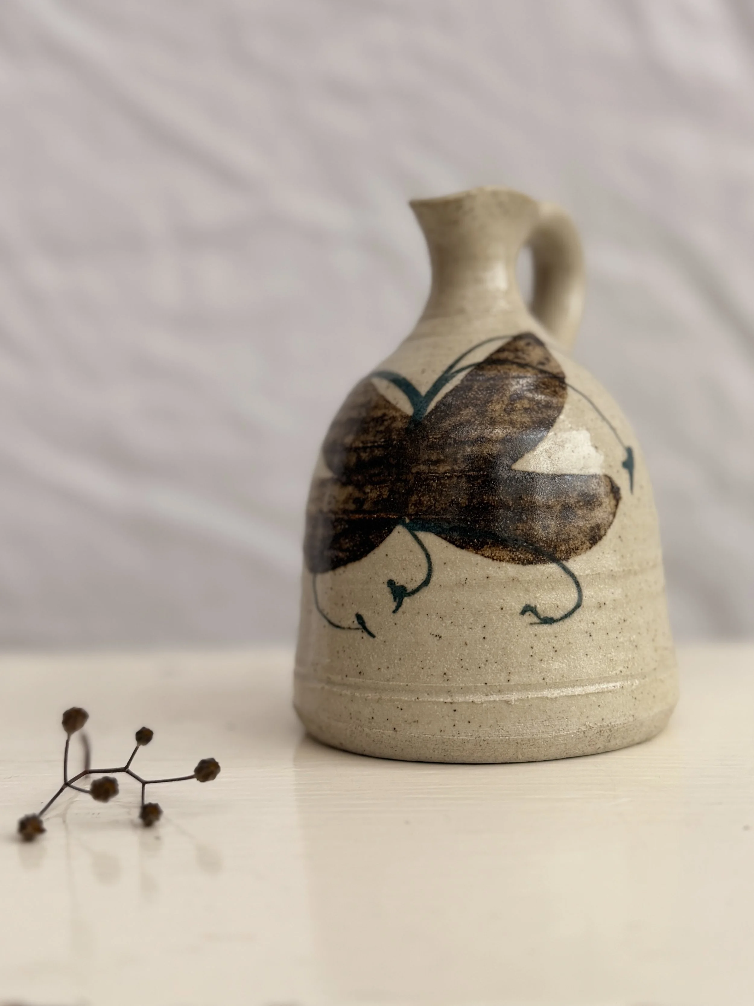 Close-up of the hand-painted details on a vintage Cornish stoneware jug by Rashleigh Pottery.