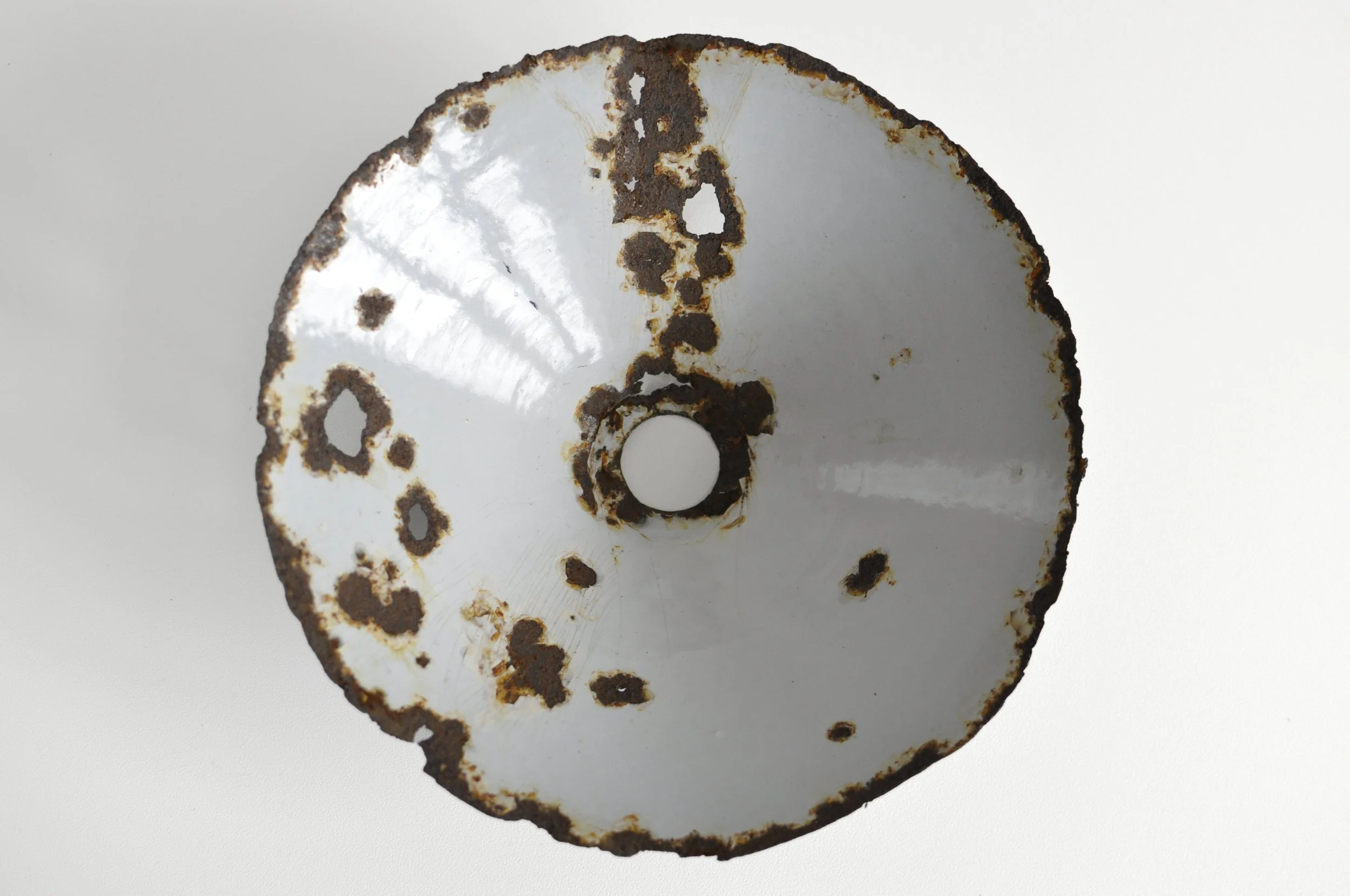 Aged white interior of a reclaimed factory metal pendant light.