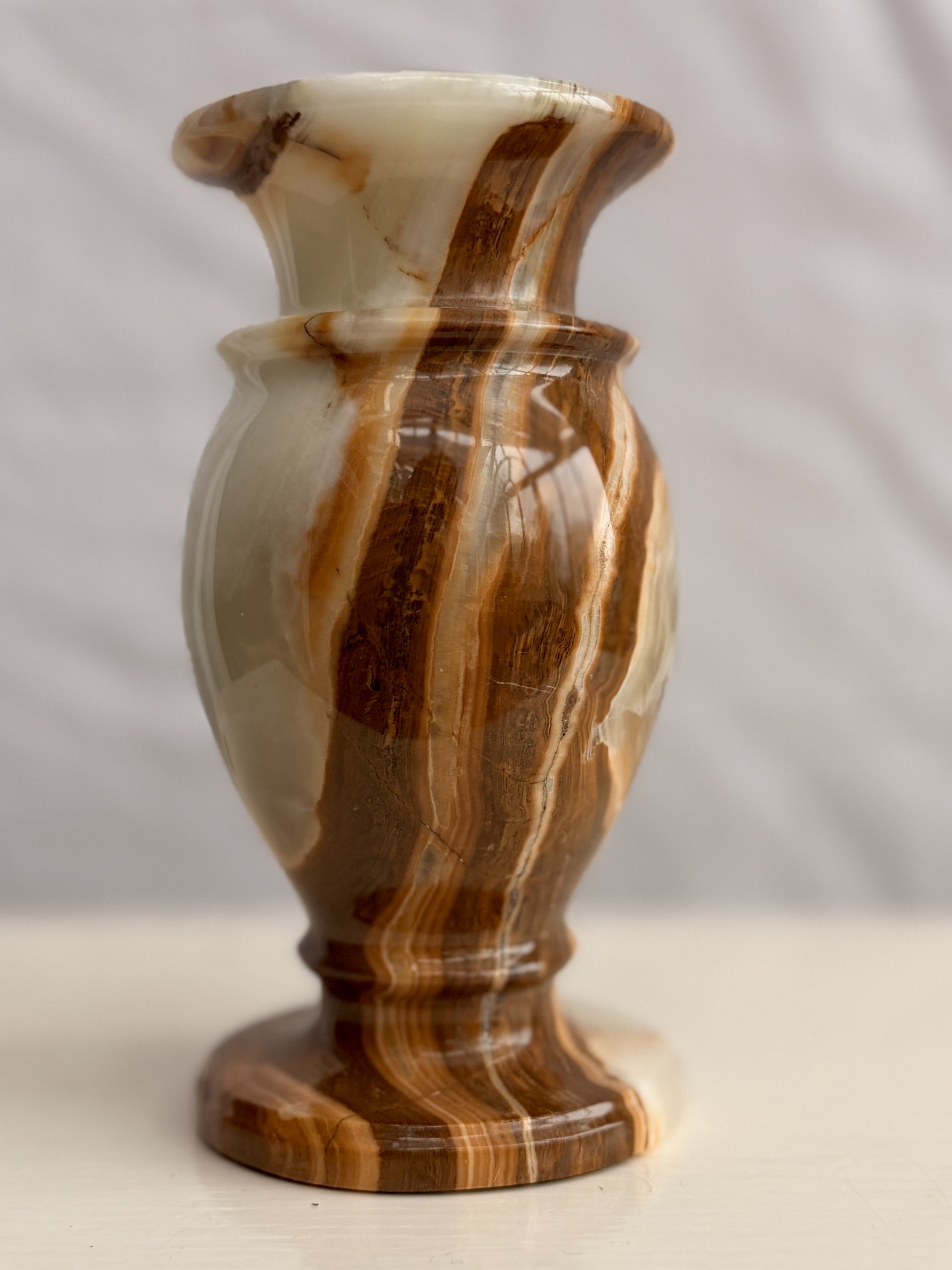 Close-up of the tactile, polished surface of a natural onyx stone vase from Roof + Roost.