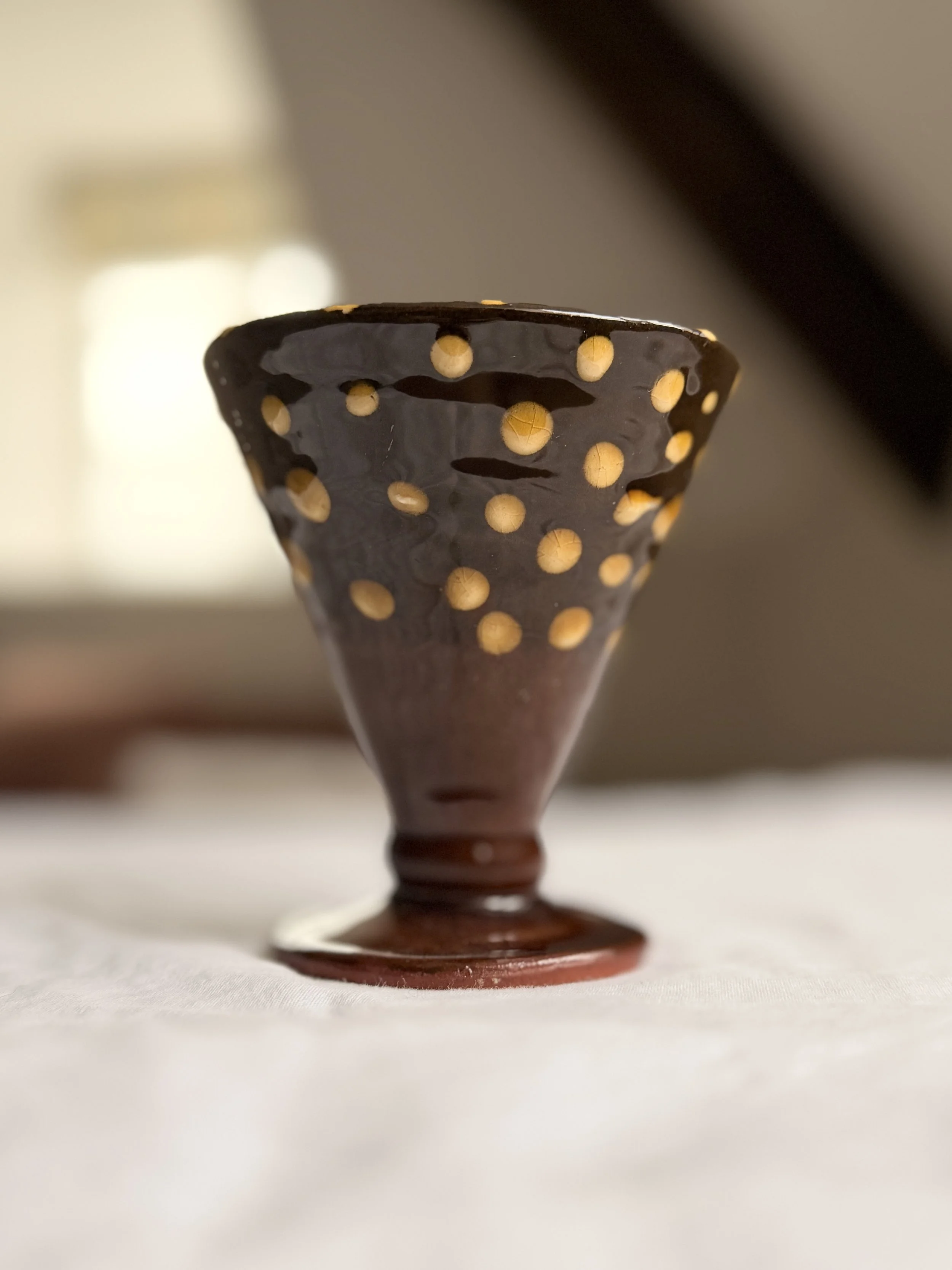 Side view of a footed ceramic bowl highlighting the elegant pedestal base and rustic pottery style.