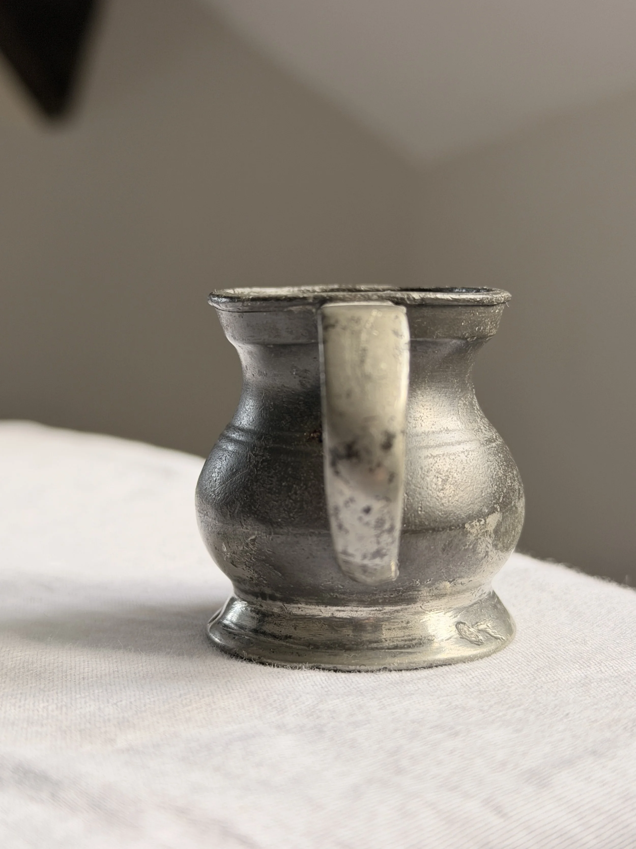 Primitive Victorian barware: a small pot-bellied pewter measure for spirits.