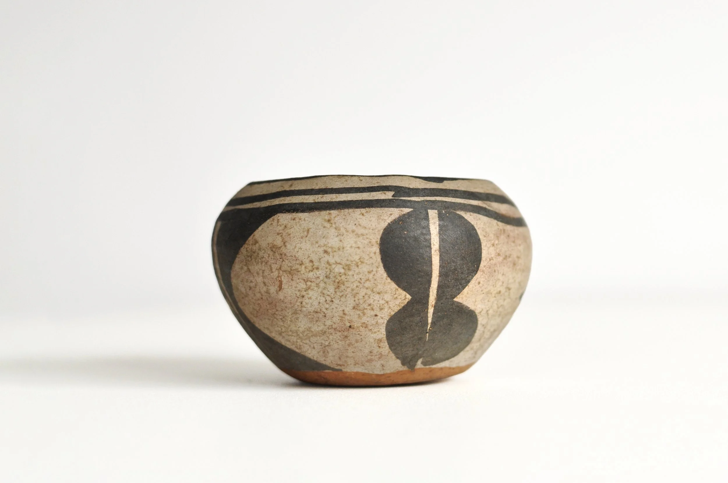 Close-up of black geometric motifs on a cream slip Native American bowl.