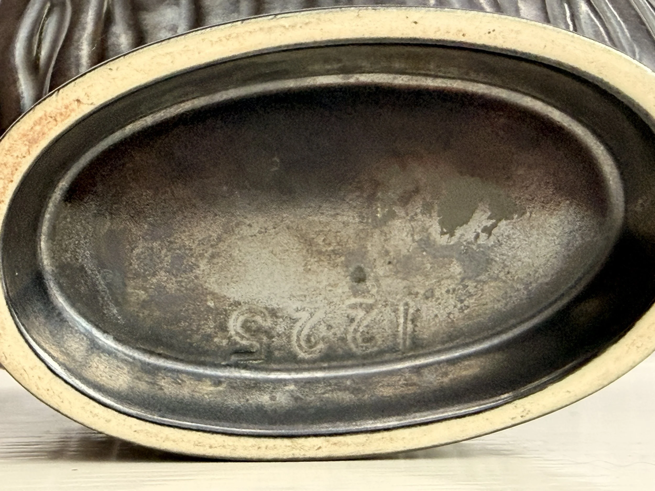 A shot of the base of the black vase showing its 1225 impressed stamp..