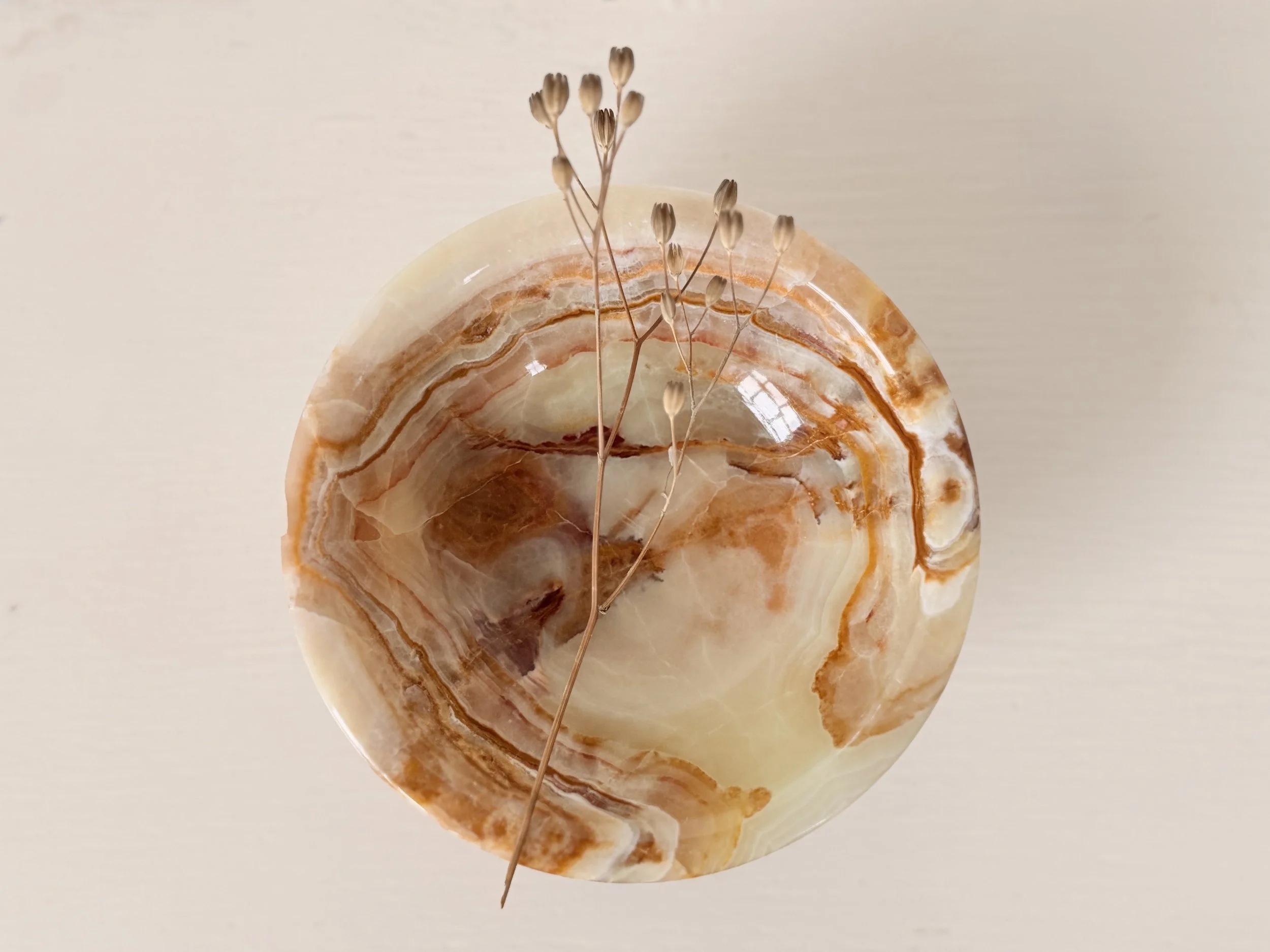 Top-down view showing the natural swirling grain and amber patterns inside the onyx stone bowl.