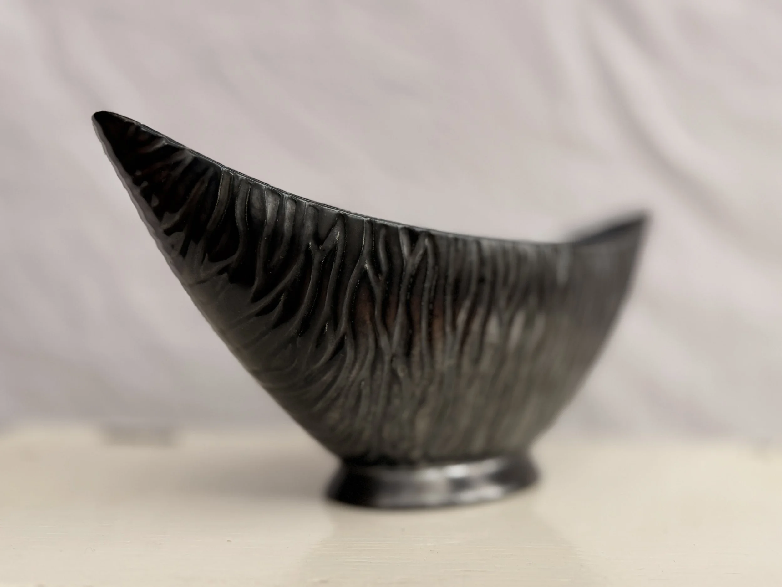 Detail of the tapered ends of the vintage 1960s black gondola-style vase.