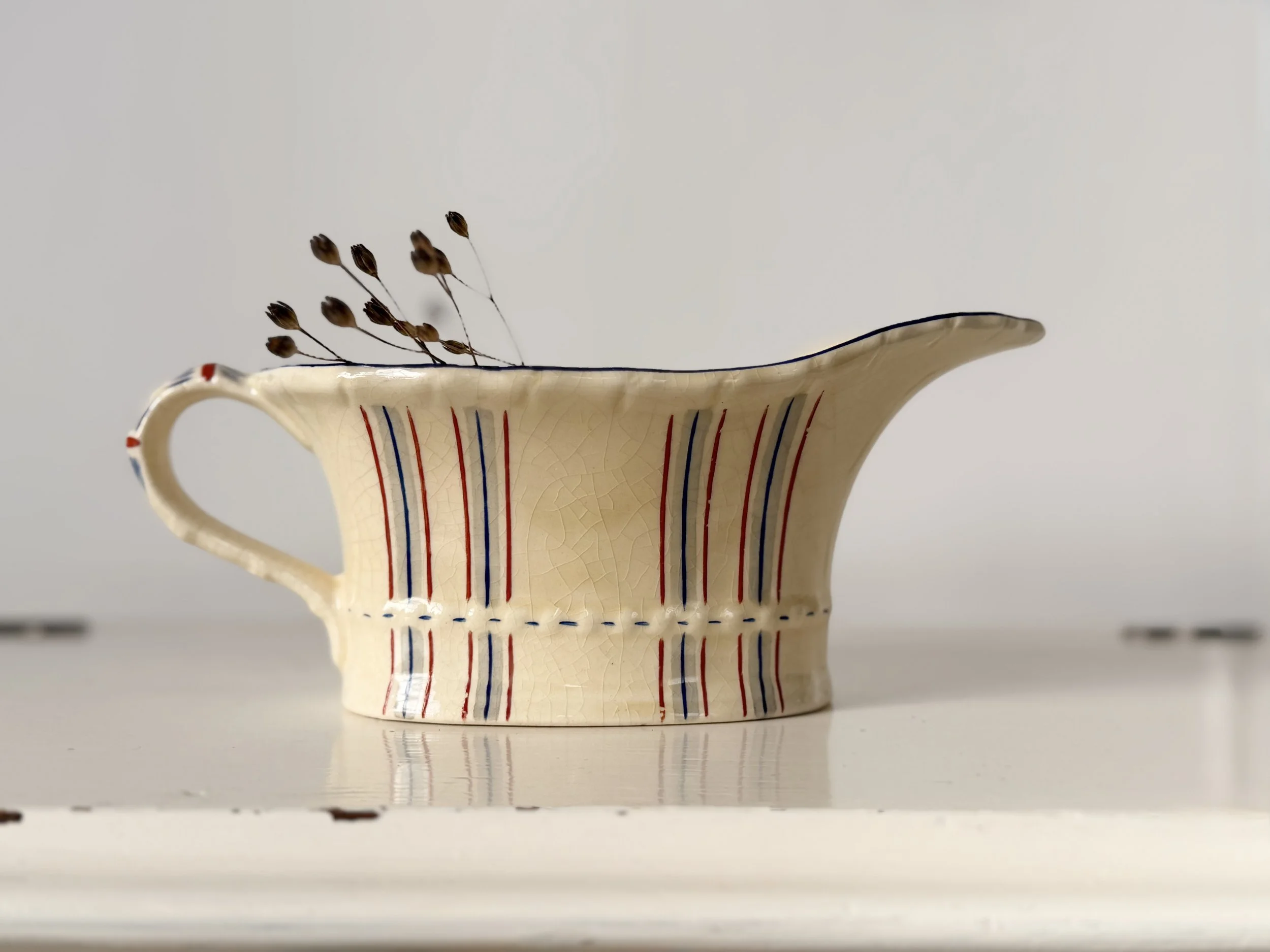 Elegant 1930s scalloped gravy boat in ivory creamware with minimalist feather-stripe detailing.