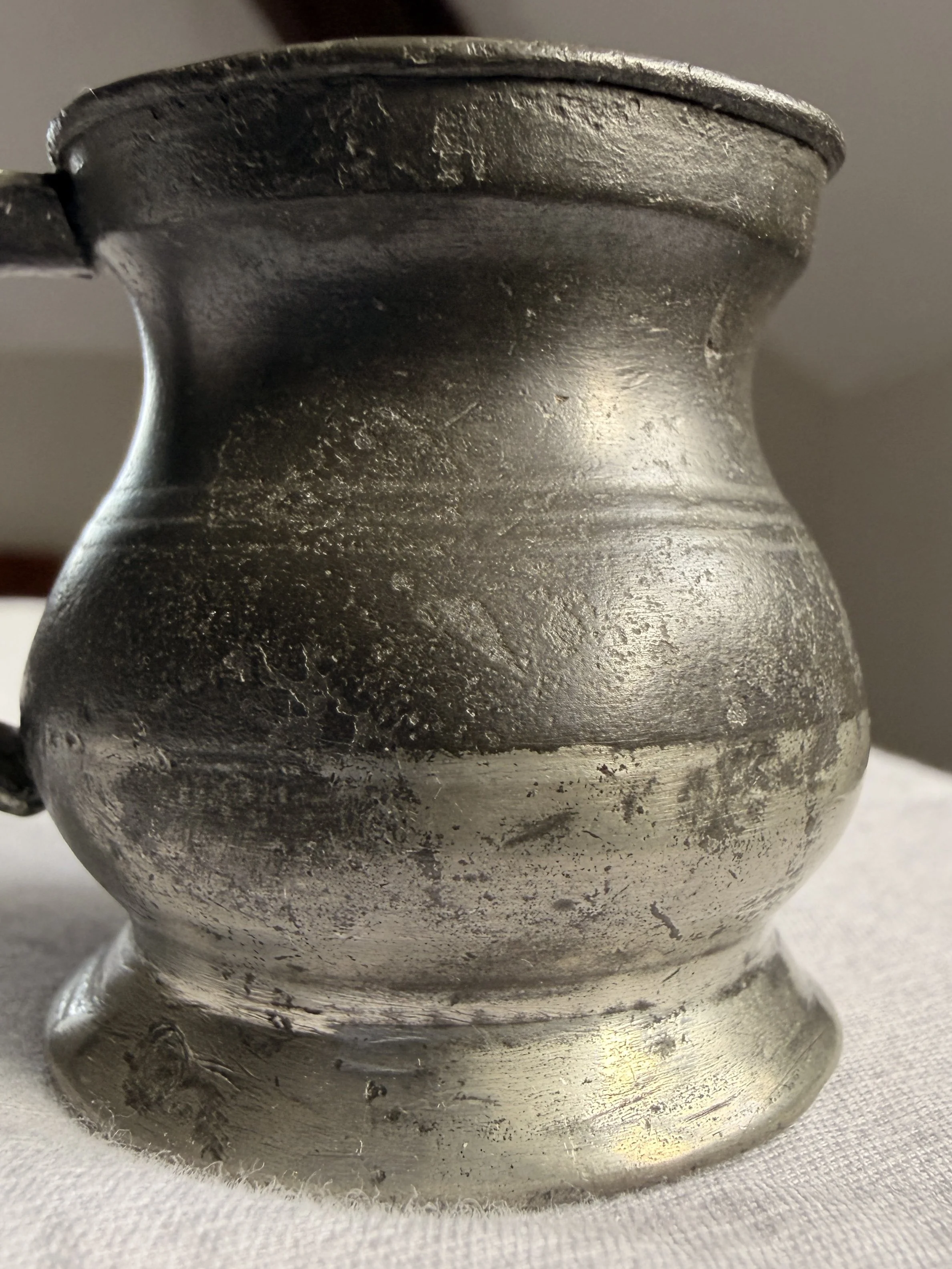 Detailed shot of the unpolished gunmetal patina on an antique tavern cup.