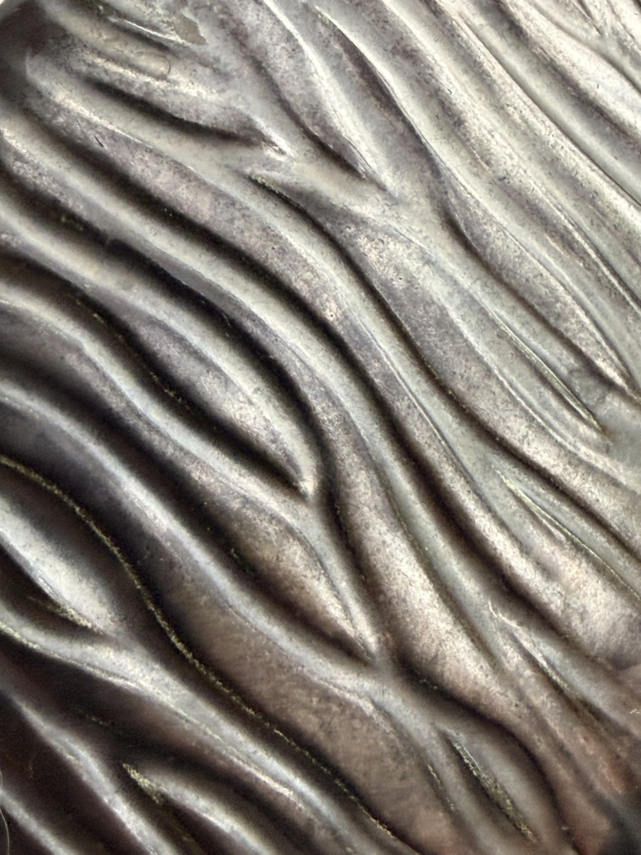 Close-up of the ribbed texture on the exterior of the black ceramic vase.