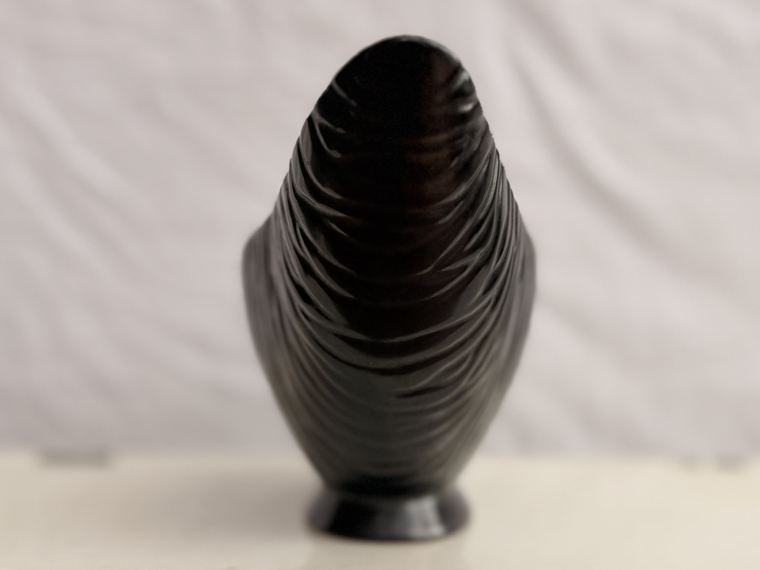 Front-facing view of the symmetrical black mid-century modern boat-shaped vase.