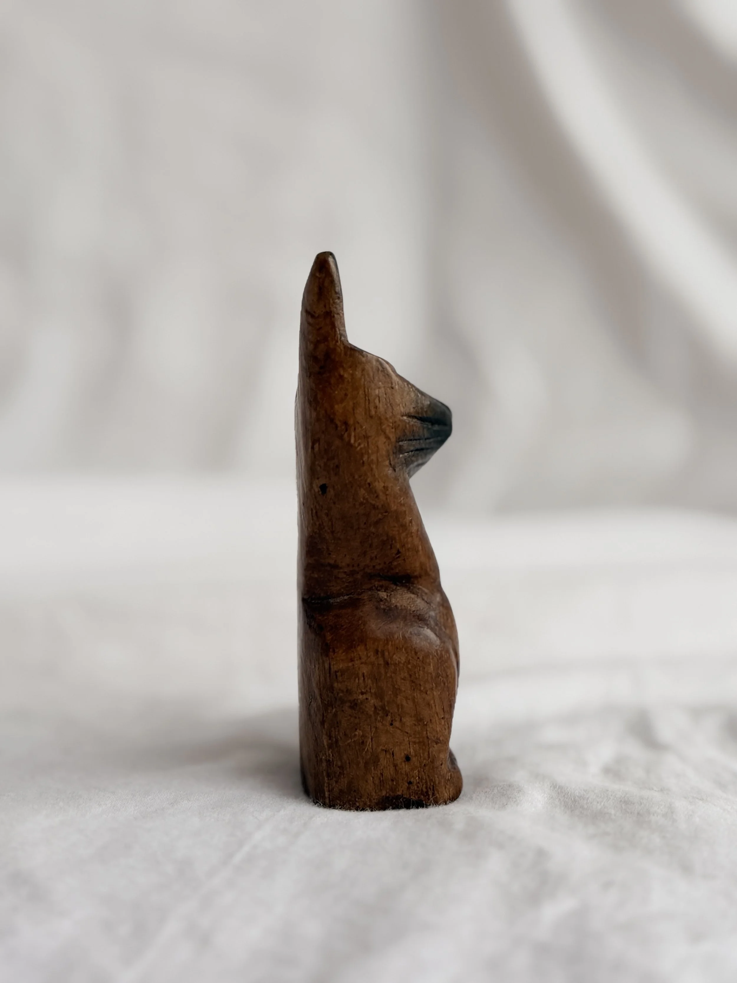 Side profile of a vintage-style wooden cat ornament highlighting its elegant, curved silhouette.