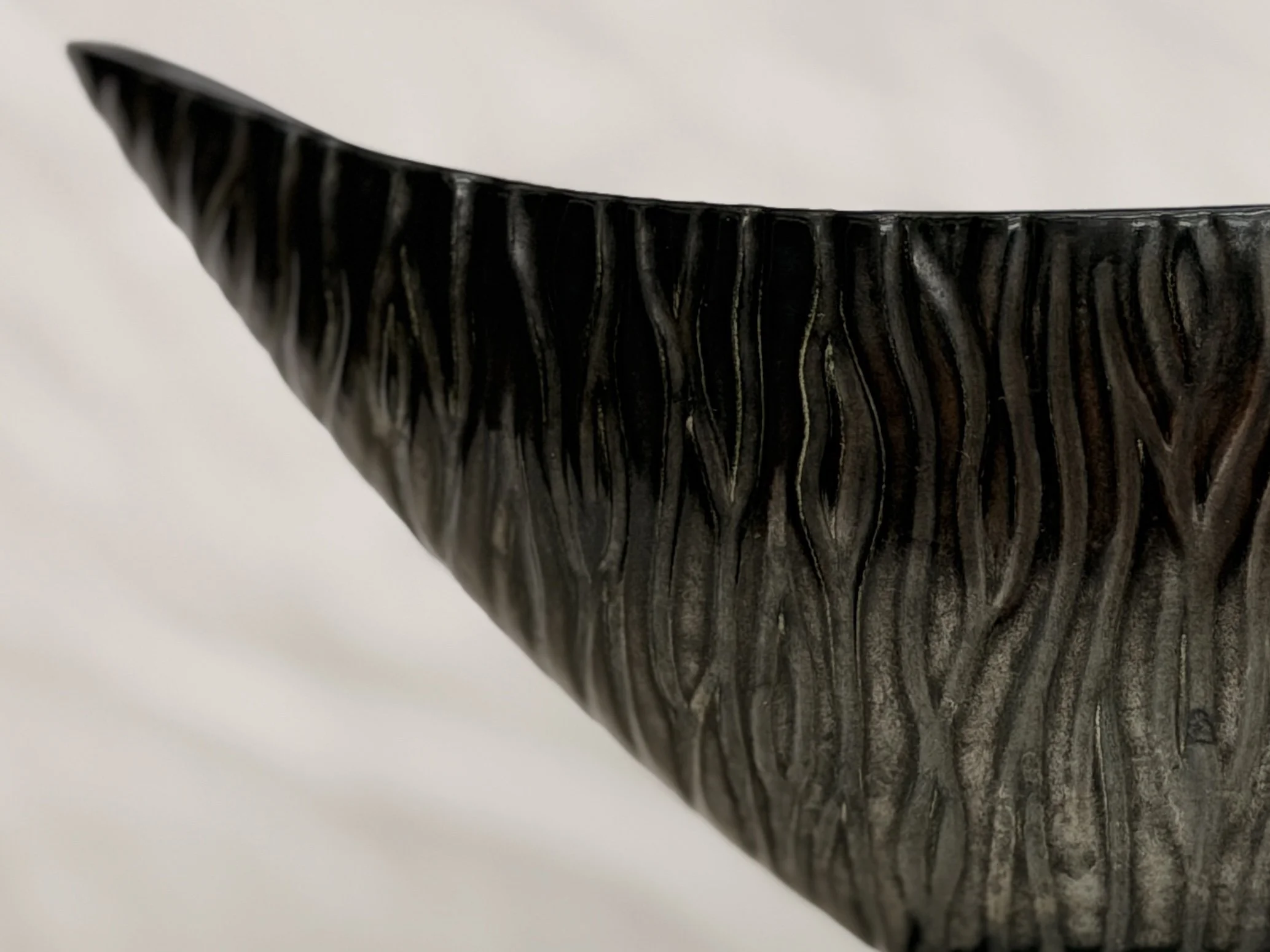 Side view of the black MCM gondola vase highlighting its elegant curved silhouette.