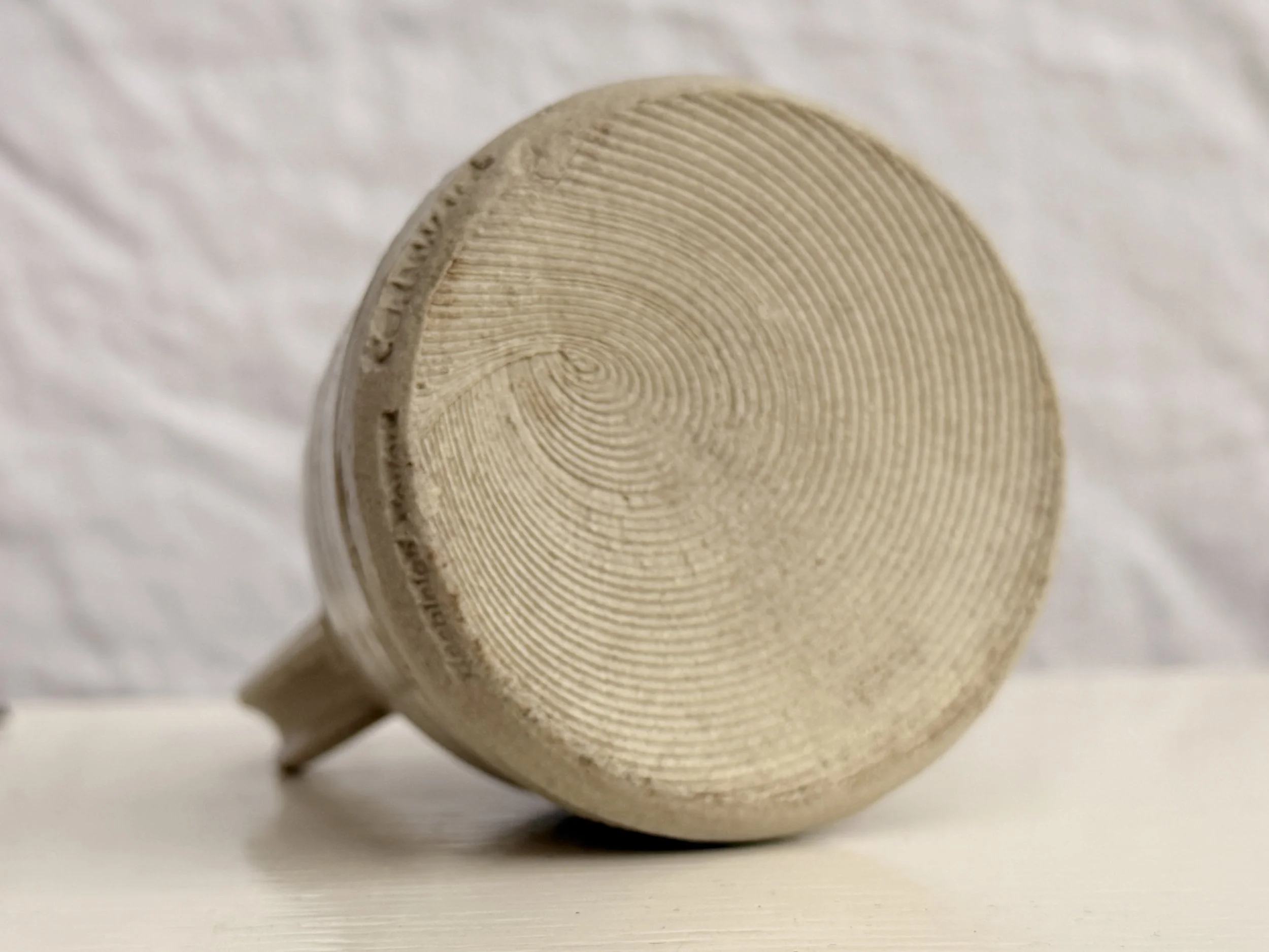 base of hand thrown studio pottery jug with swirled detail in clay