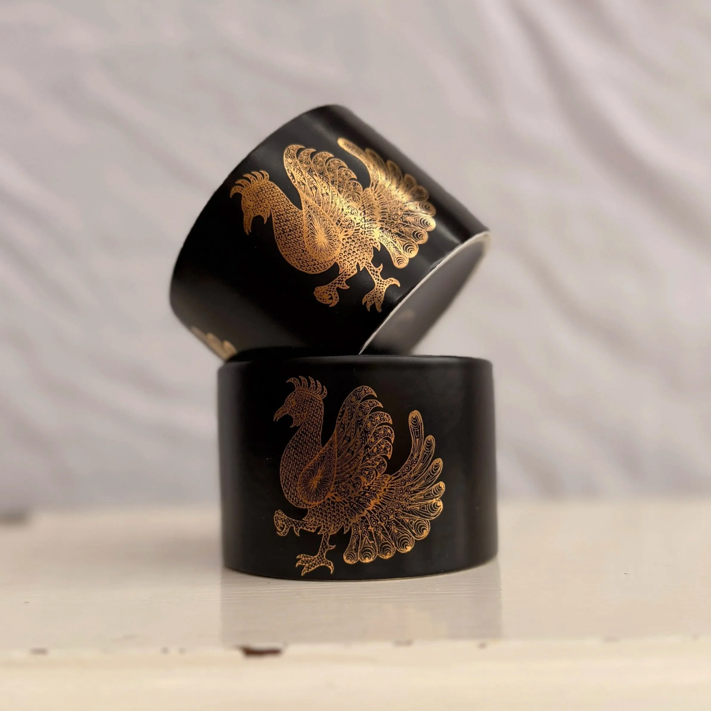 A vintage Portmeirion Phoenix sugar bowl featuring a gold phoenix design on black ceramic.