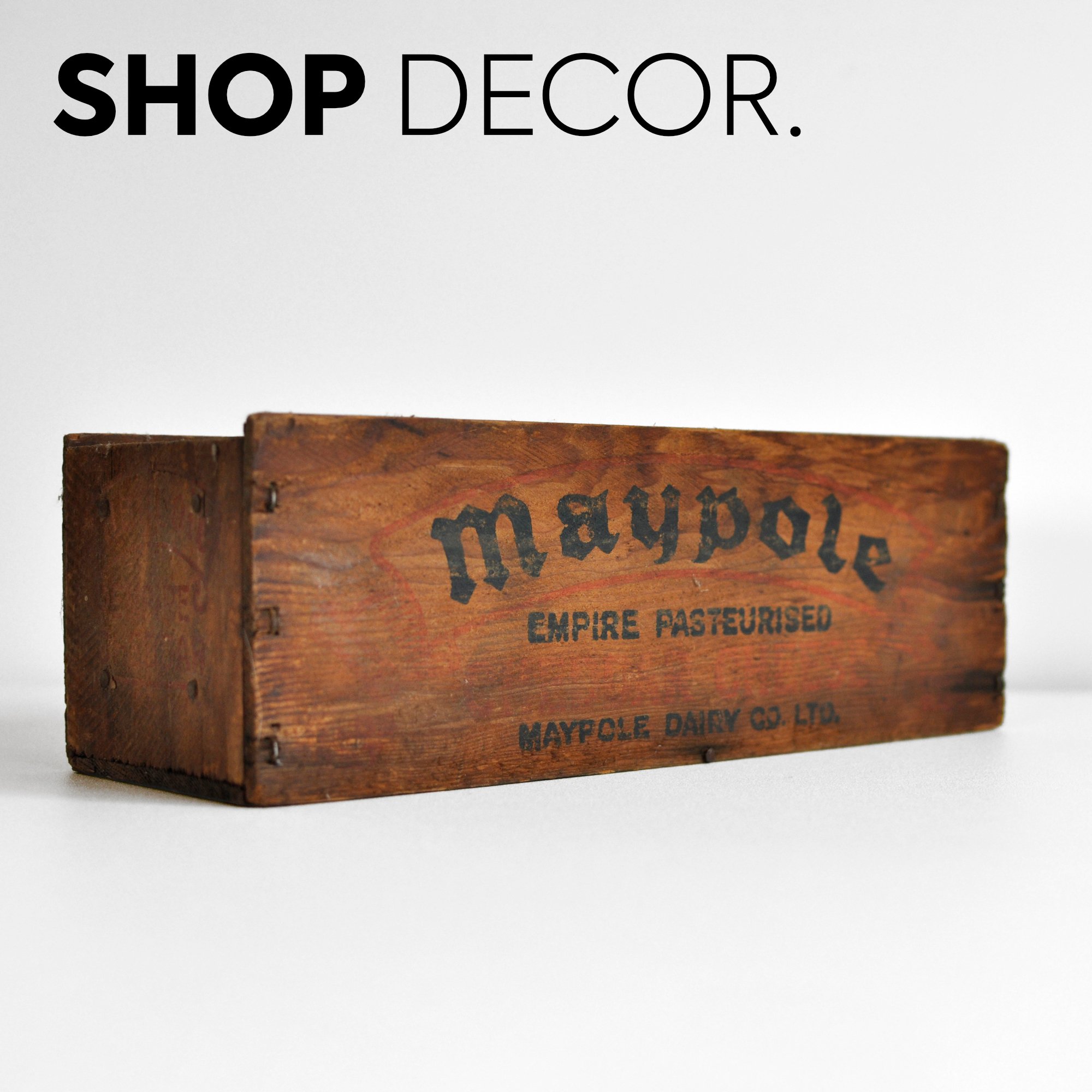 A wooden crate with Maypole branding and vintage text, used for dairy products, placed on a white background.