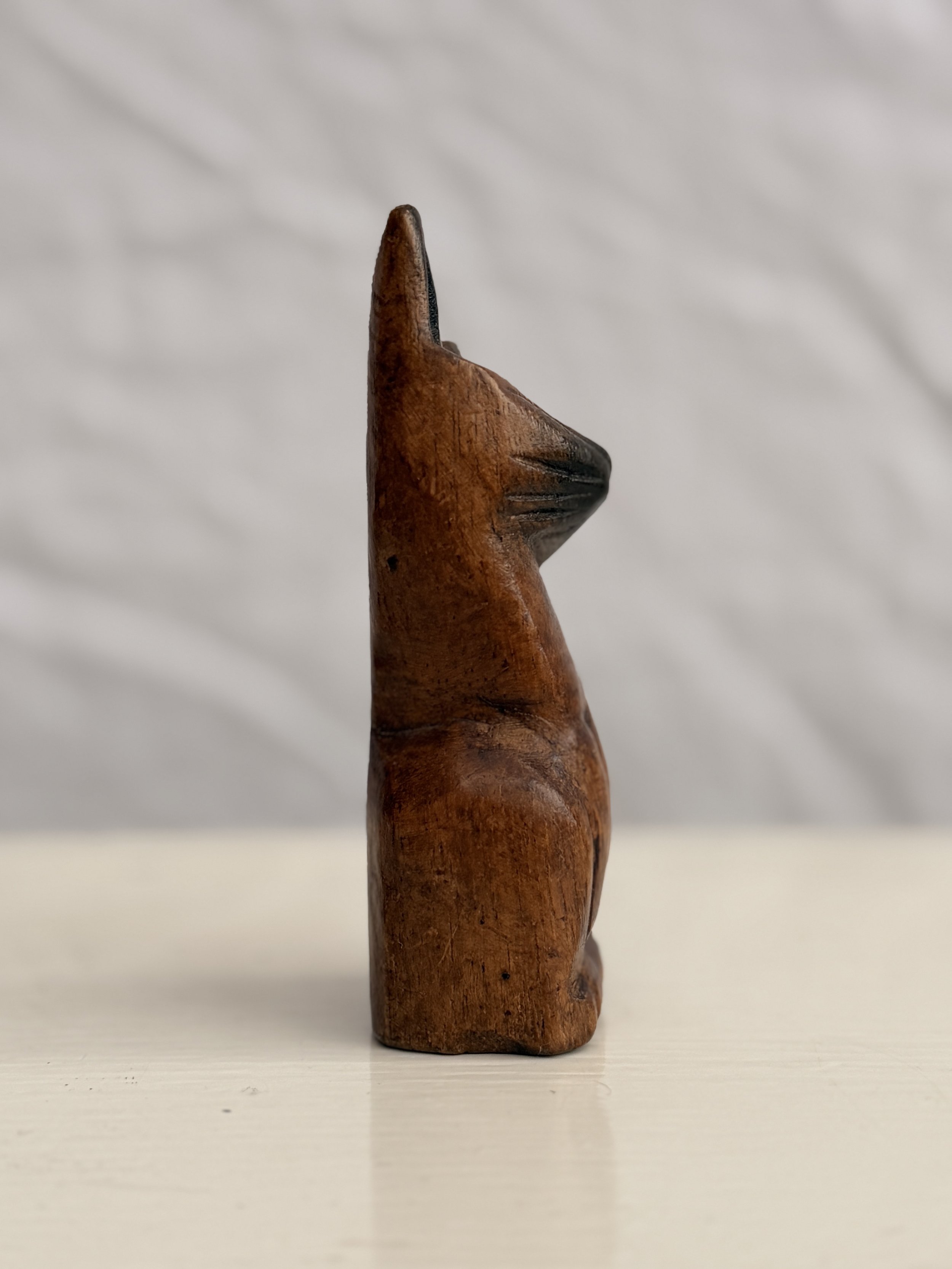 Side profile of a vintage-style wooden cat ornament highlighting its elegant, curved silhouette.