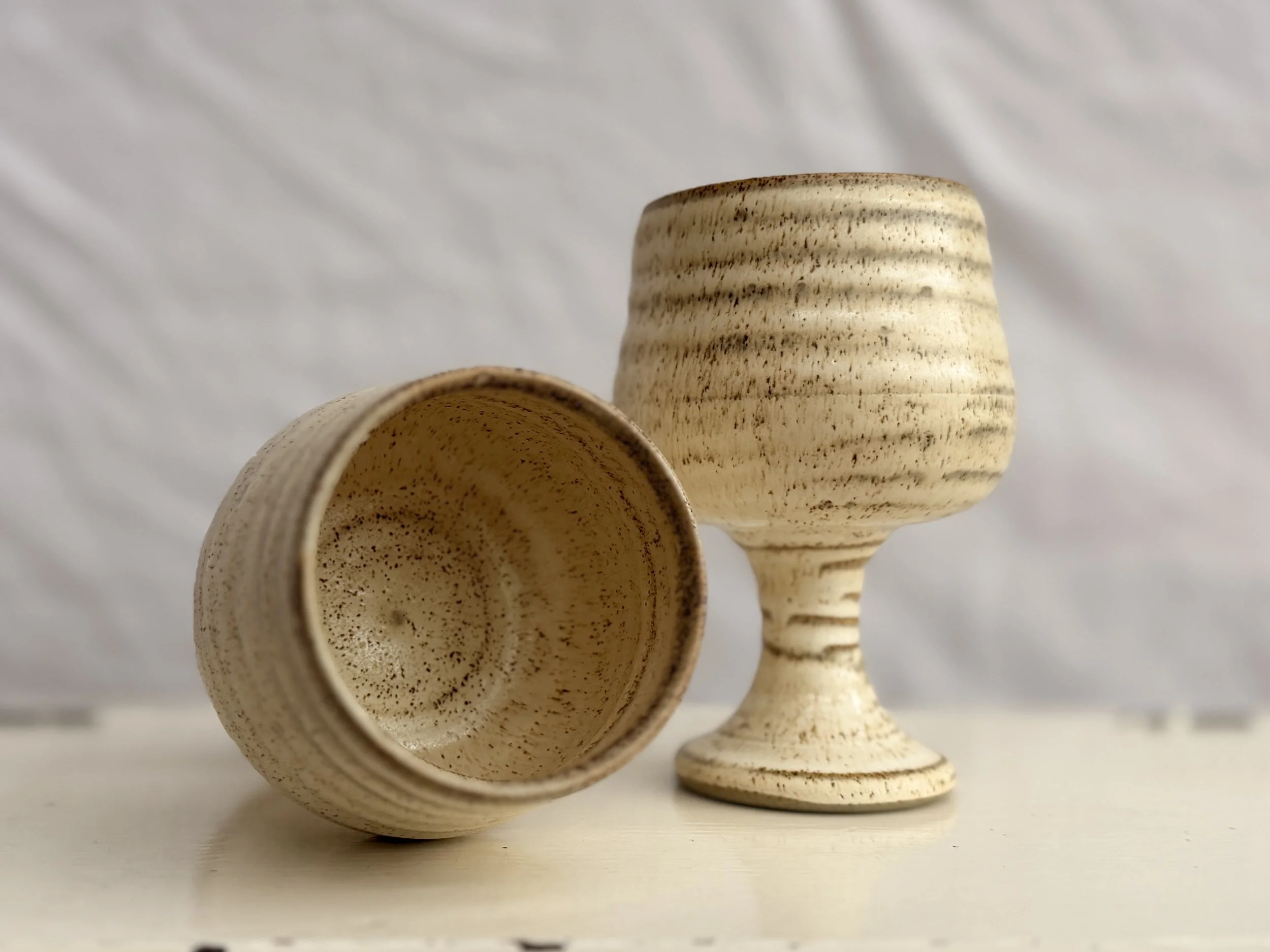A vintage set of two Grayshott wine cups in a soft beige and brown palette.