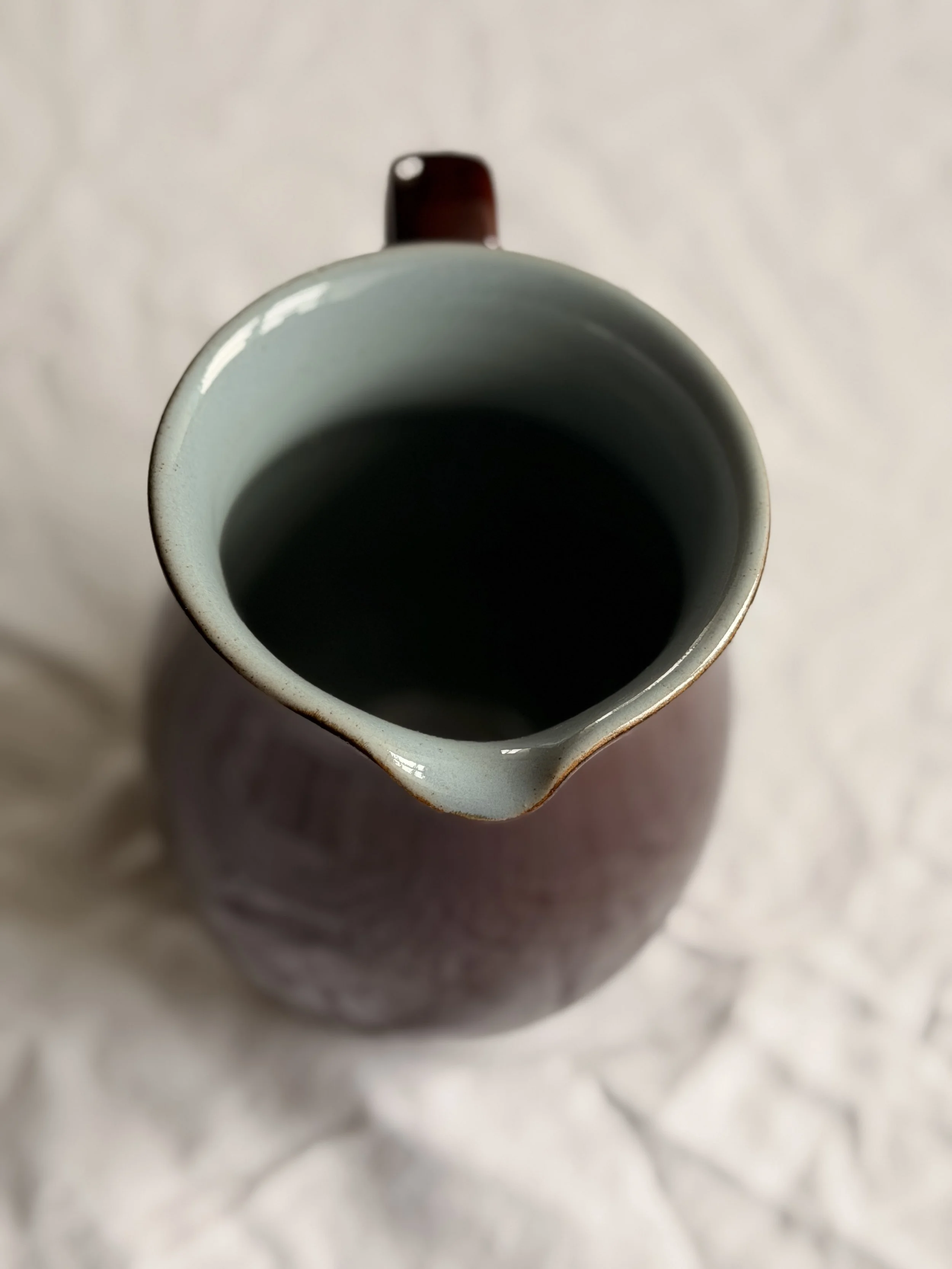 Top view of a Denby Homestead Brown jug revealing the smooth sky blue glazed interior against the dark brown rim.