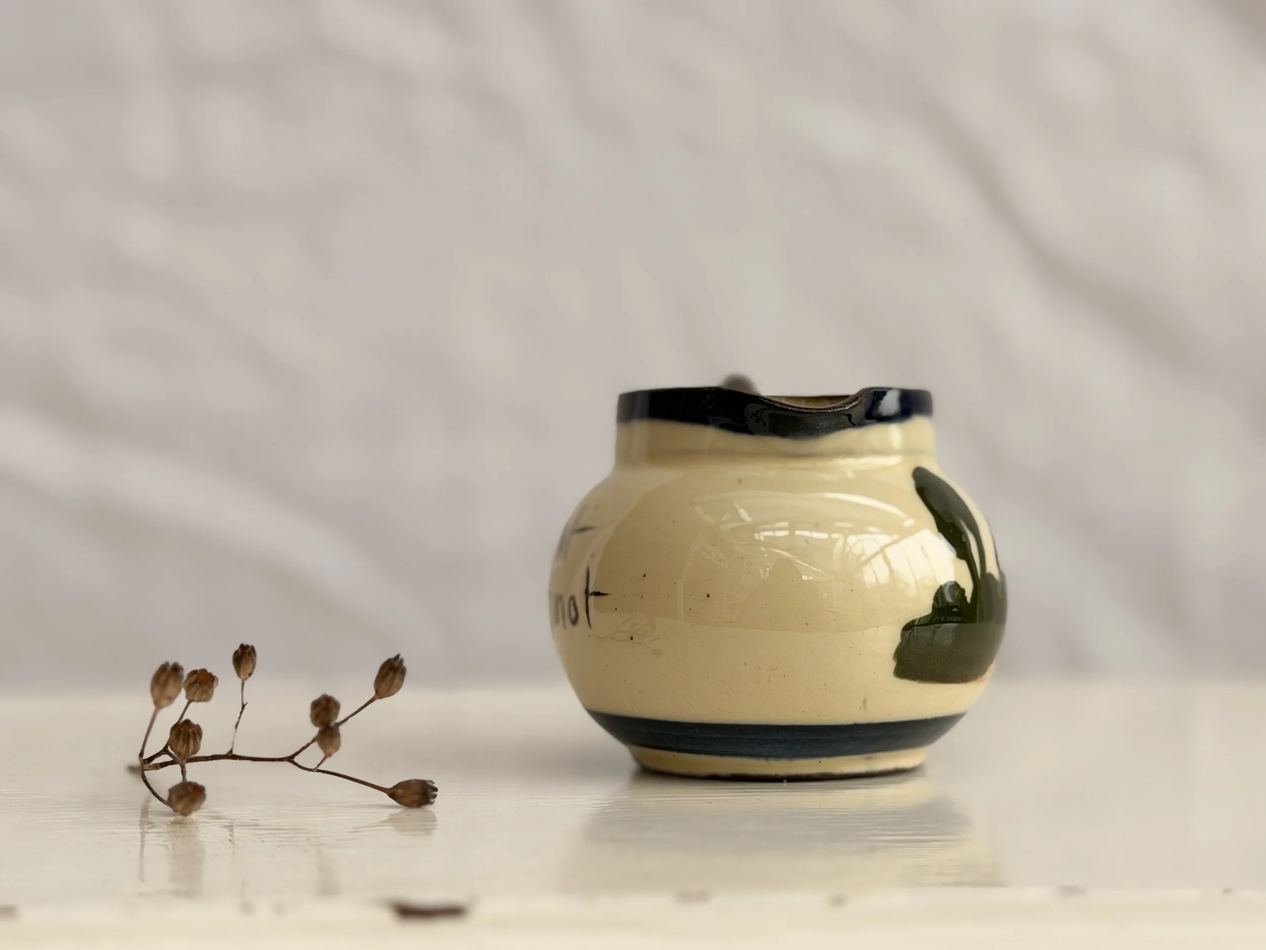 Side view of a small 1930s-style Torquay Ware jug highlighting the artisanal hand-painted details.