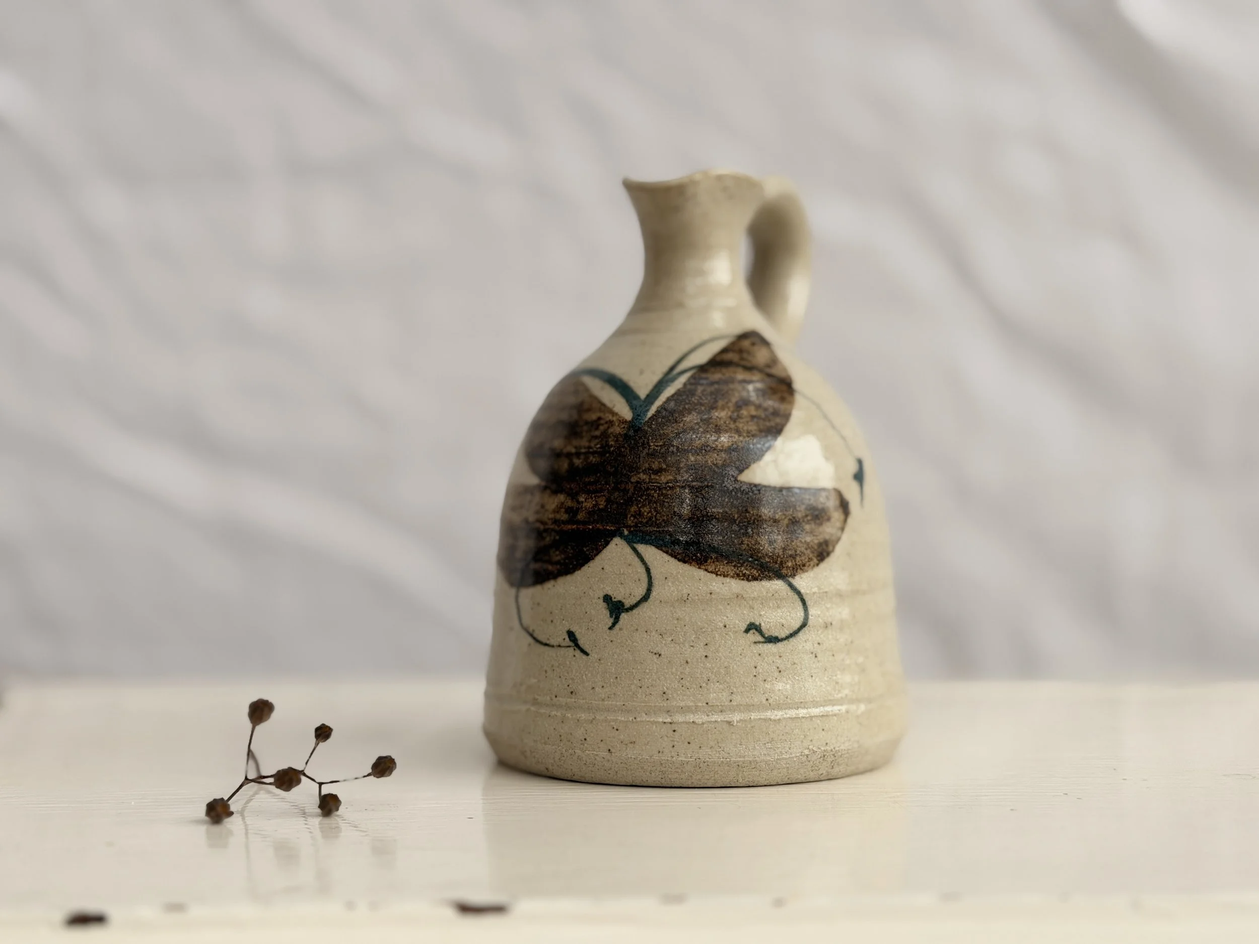 Vintage Rashleigh Pottery jug from Cornwall, featuring a hand-painted floral or leaf design on oatmeal stoneware.