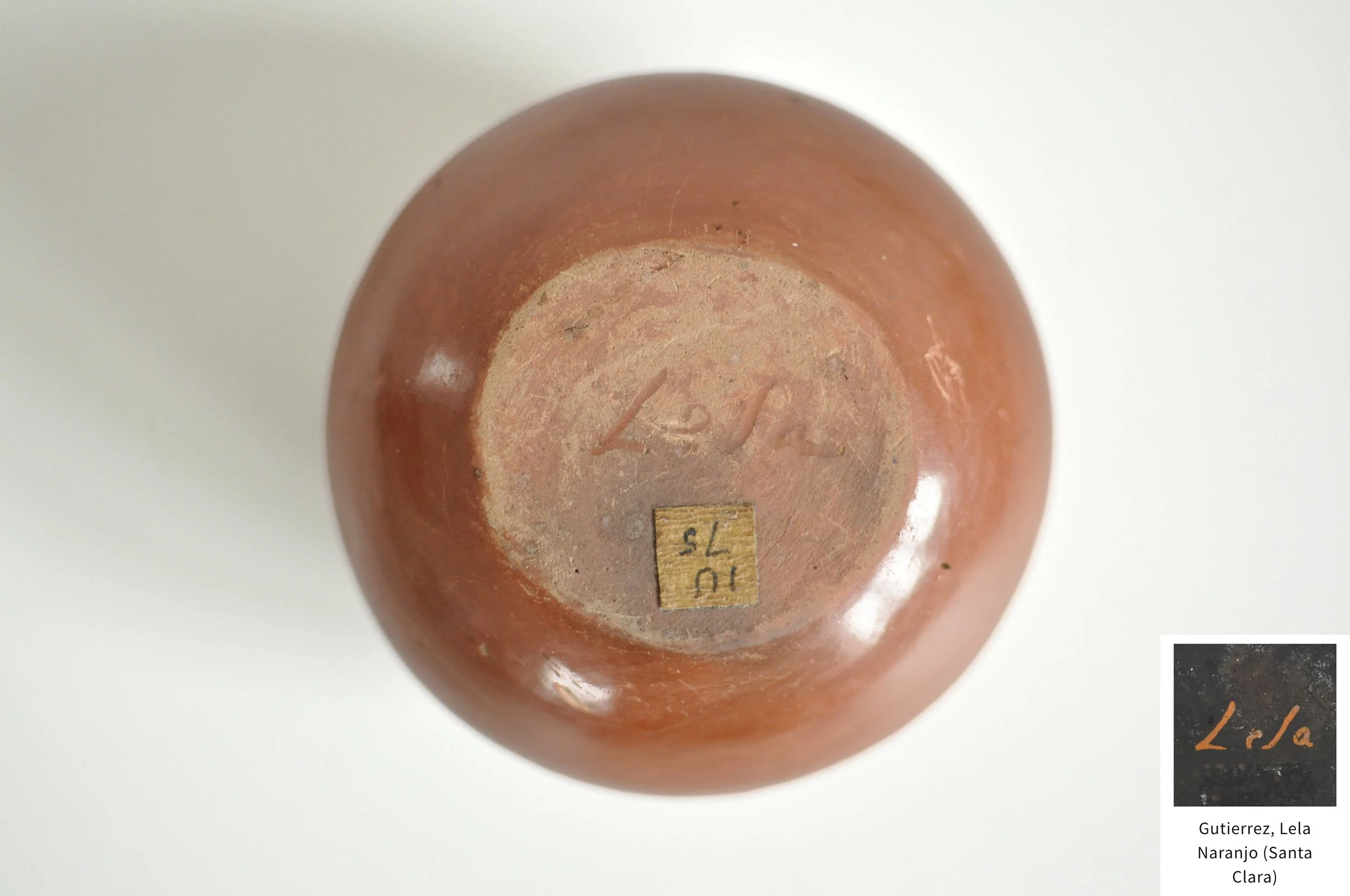 Base of antique Pueblo pottery showing early incised Lela signature.