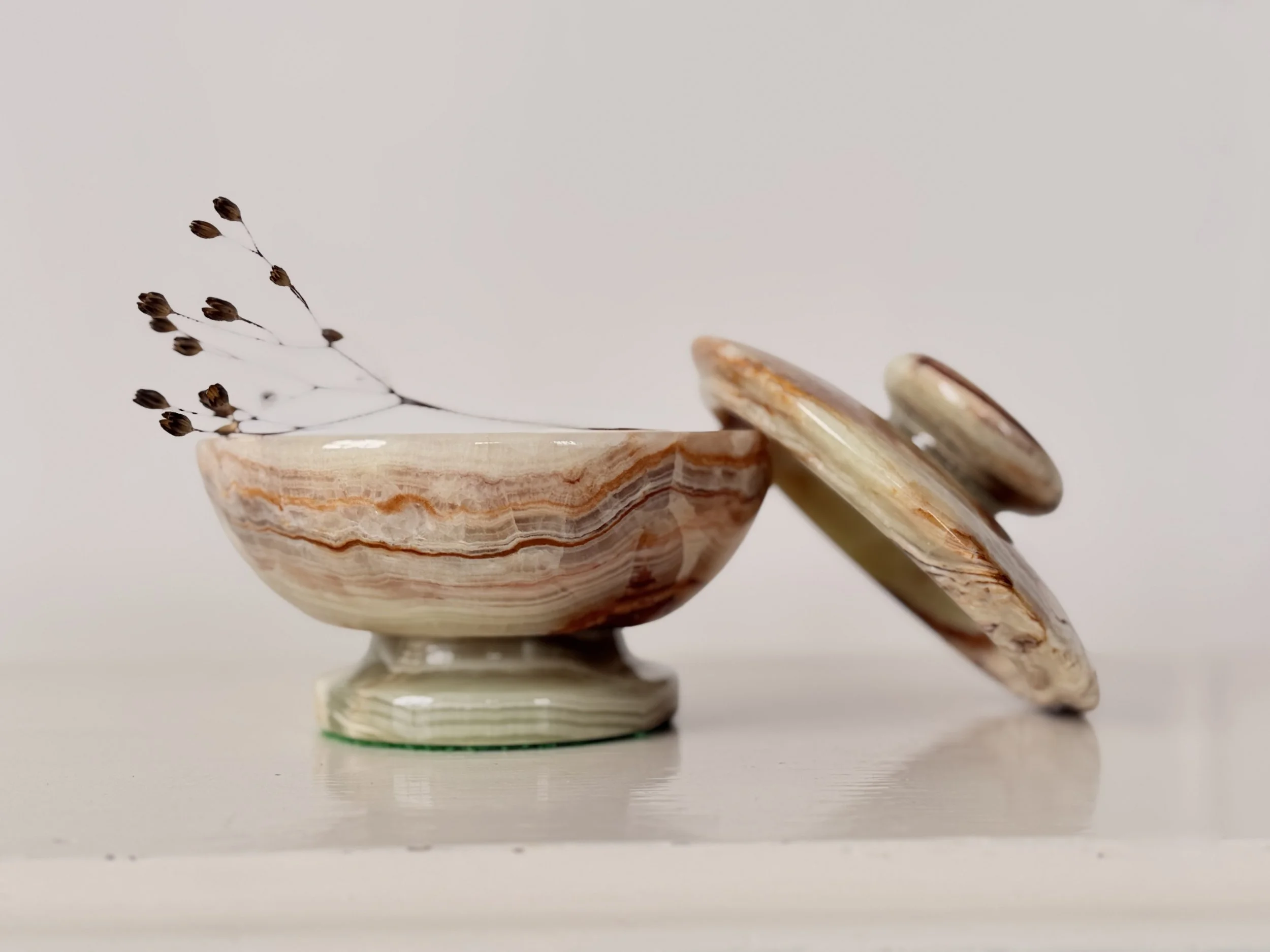 Side view of an open banded onyx jewellery bowl with the lid leaning against the base.