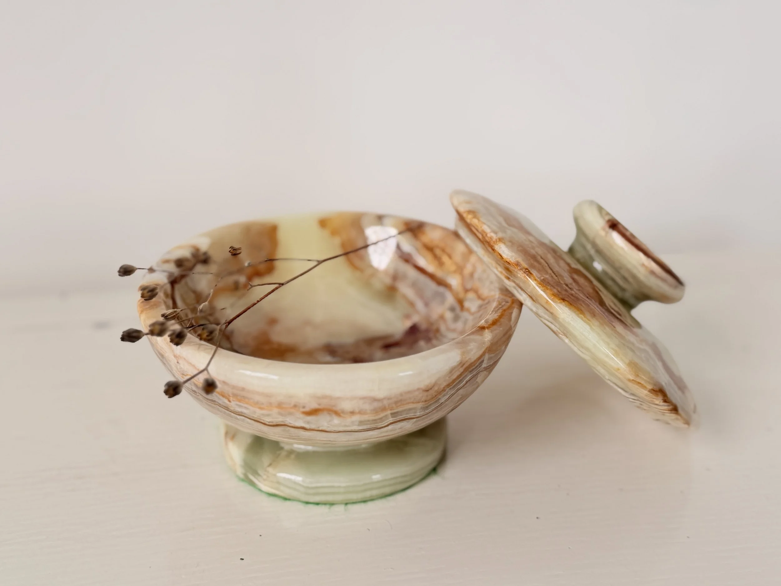 Side view of an open banded onyx jewellery bowl with the lid leaning against the base.