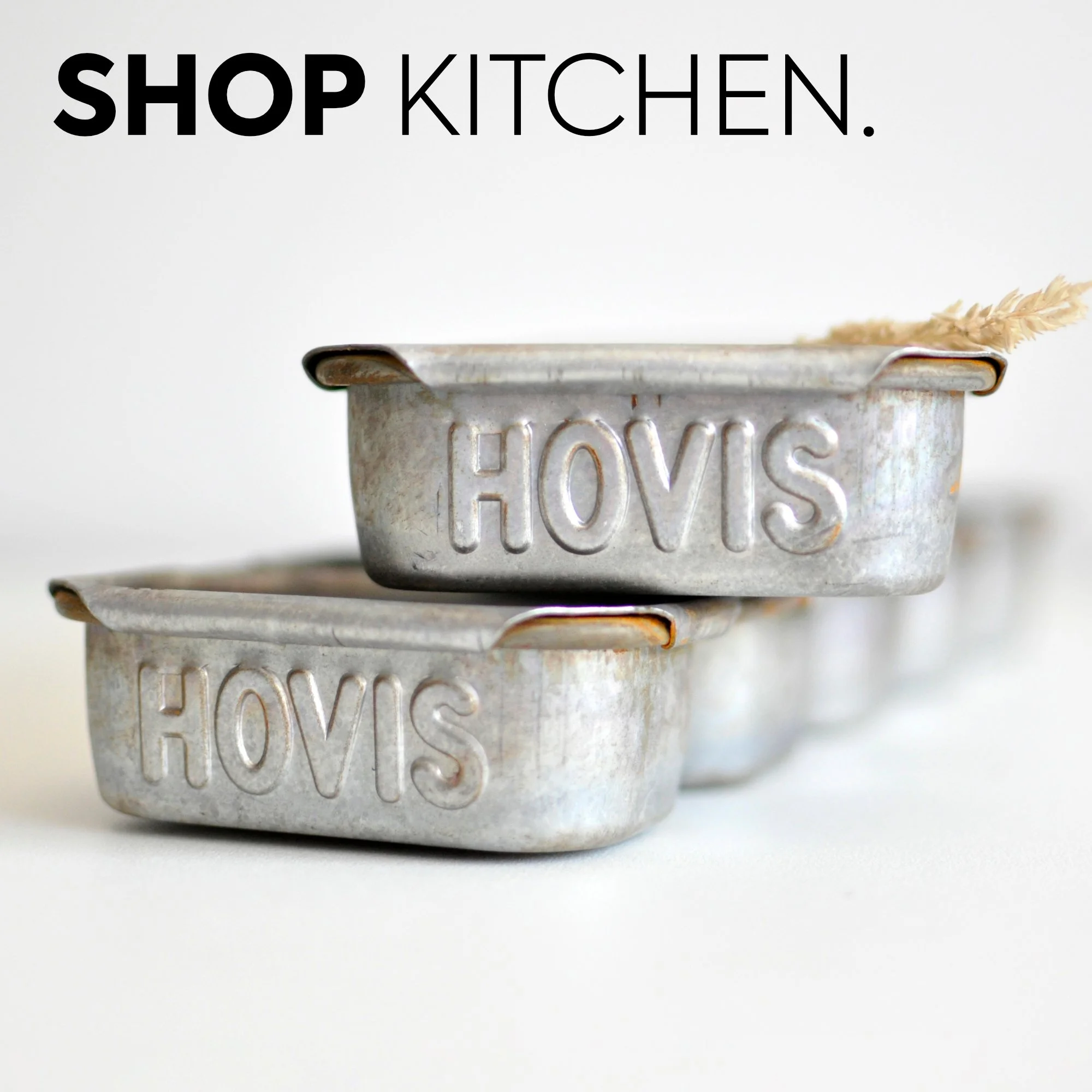 Stacked vintage metal tins with the word "HOVIS" embossed on their sides, set against a plain white background.