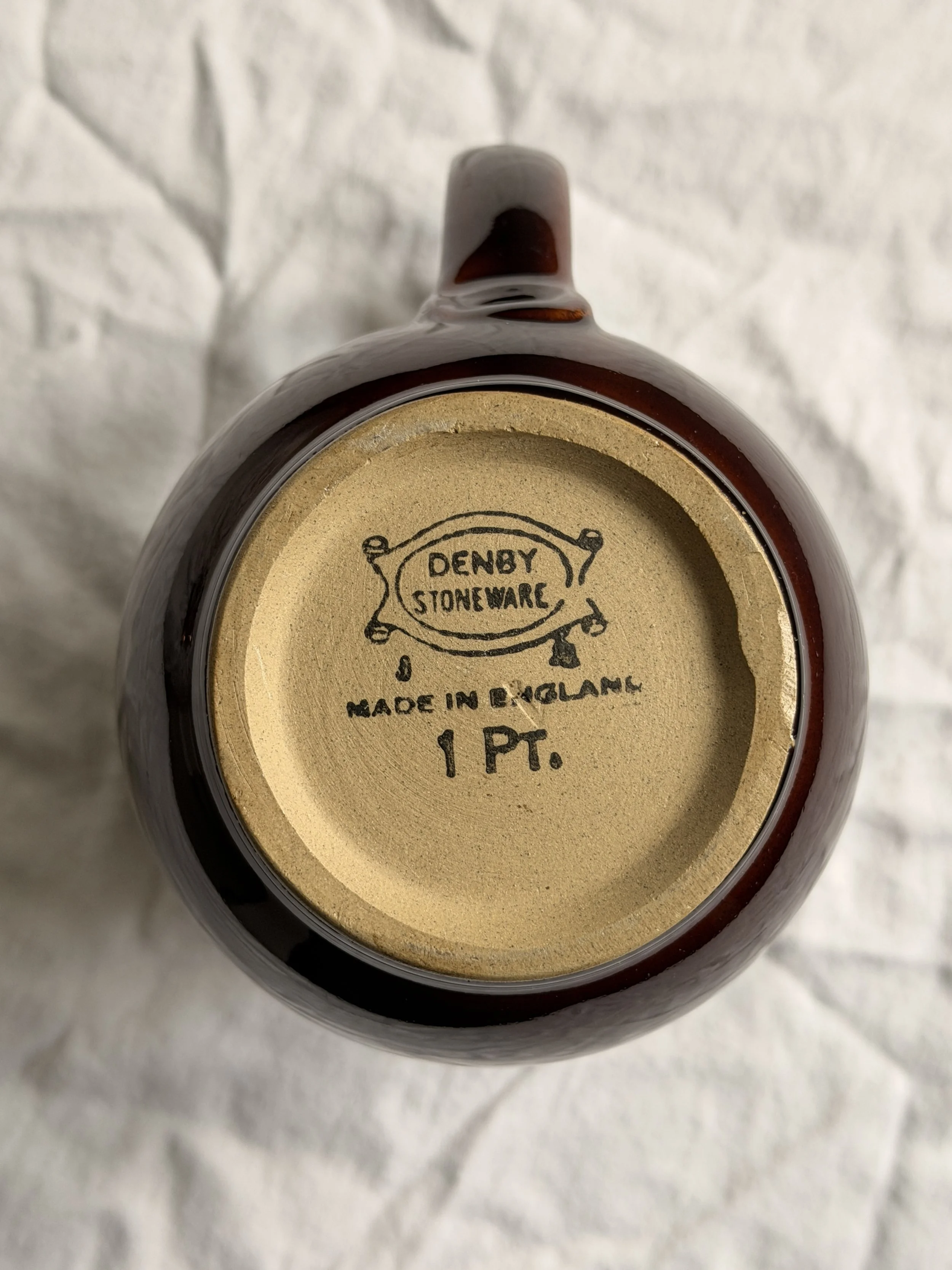 The base of a Denby Homestead Brown jug showing the authentic maker's mark and the 1 PT capacity stamp.