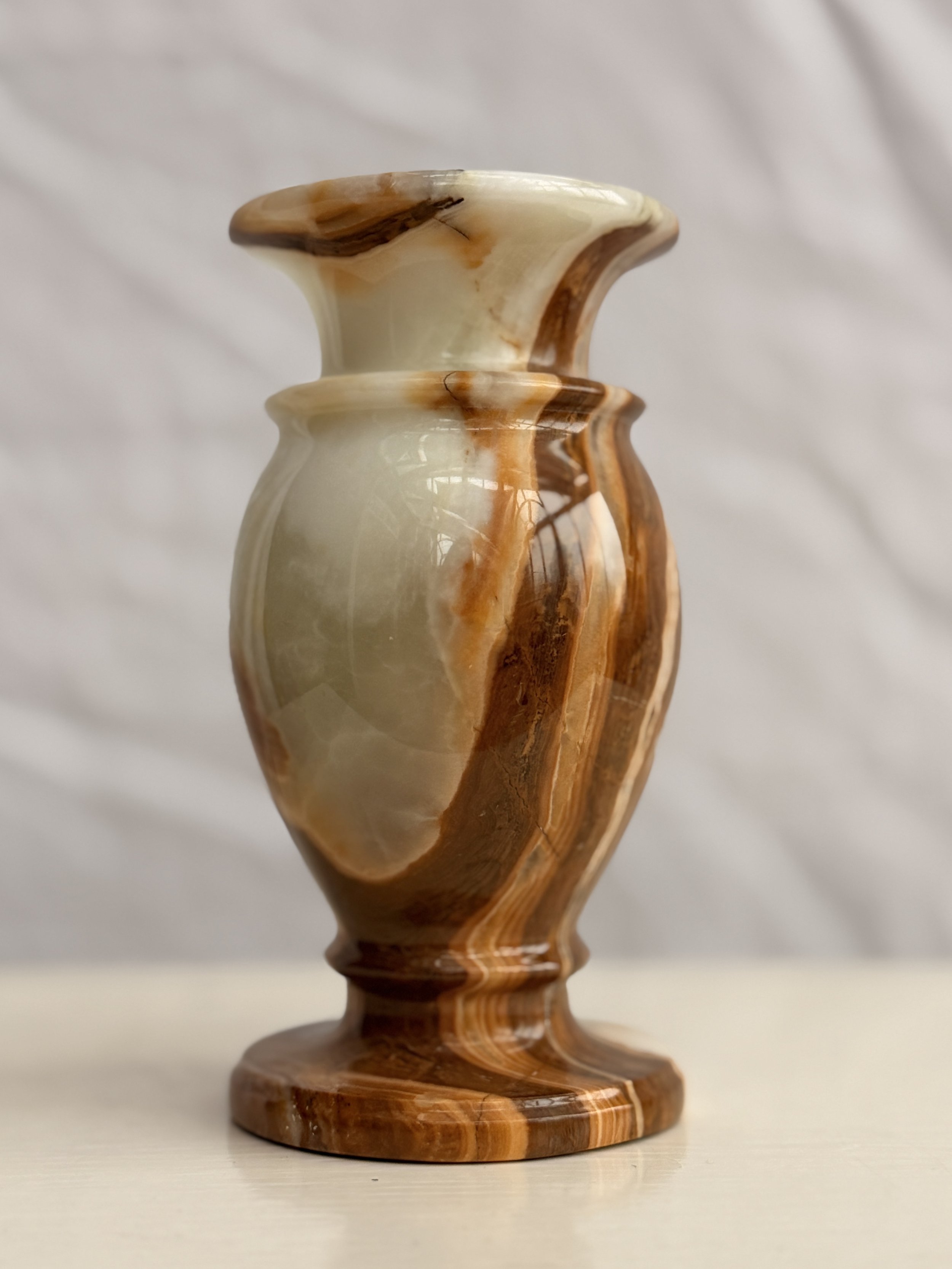 Close-up of the tactile, polished surface of a natural onyx stone vase from Roof + Roost.
