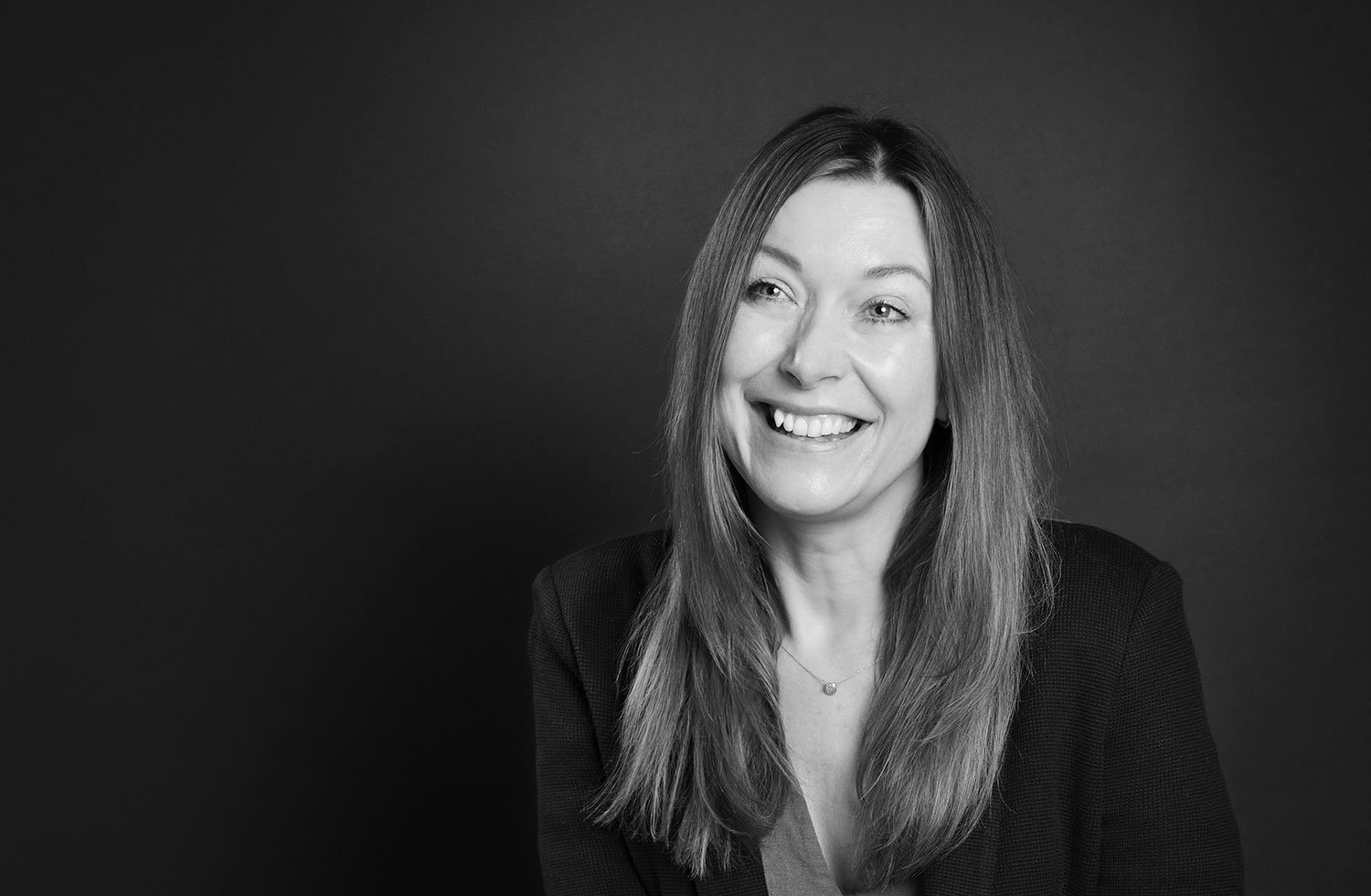smiling woman against plain background