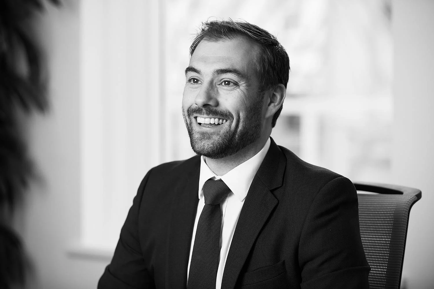 Smiling man in suit sitting down