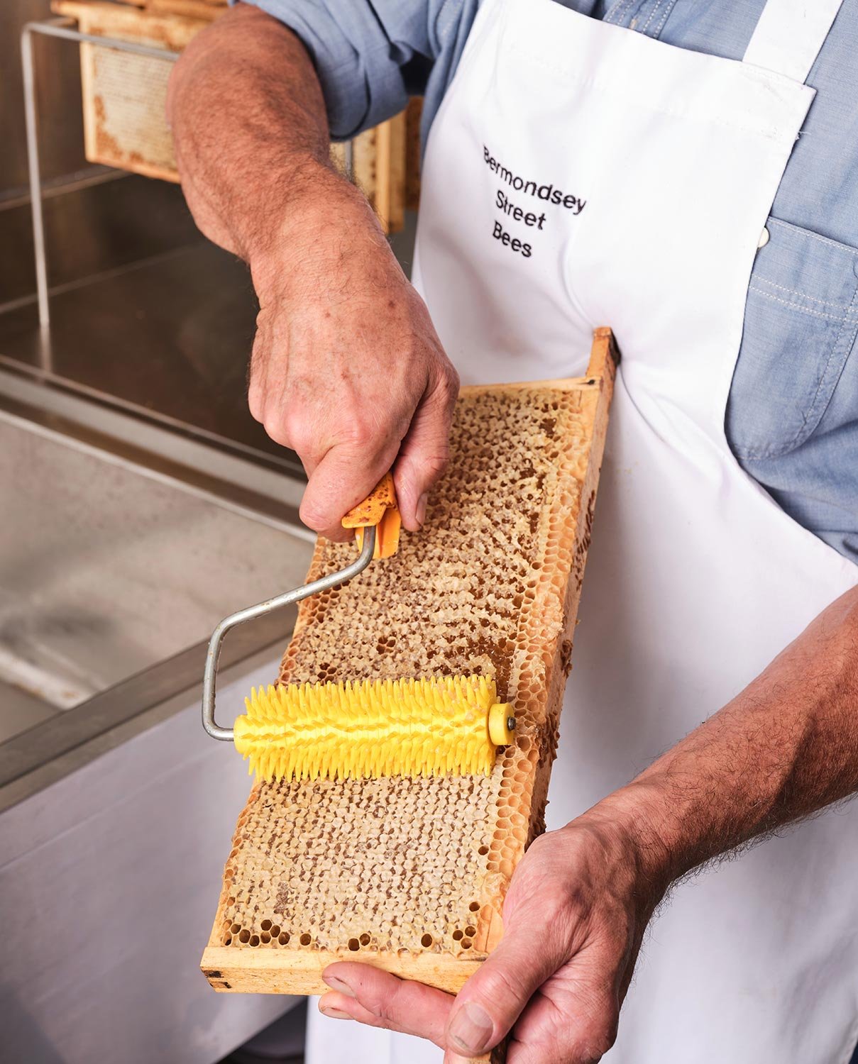 Beekeeper decaping honeycomb